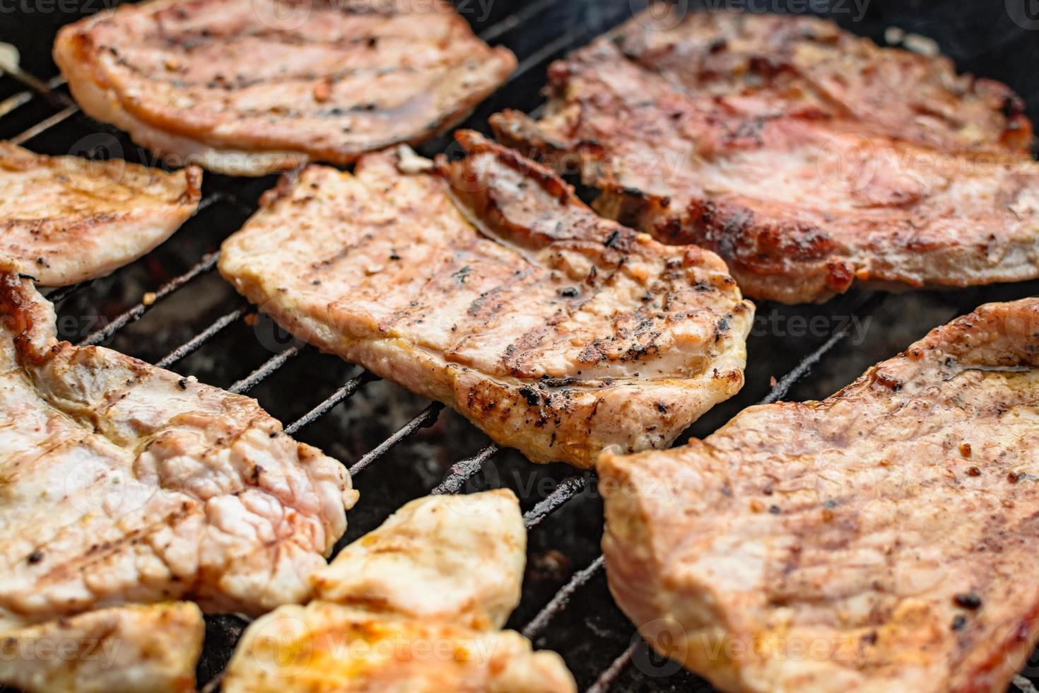 Grilled meat, pork, beef and chicken meat on barbecue, grill. Shallow depth of field. photo