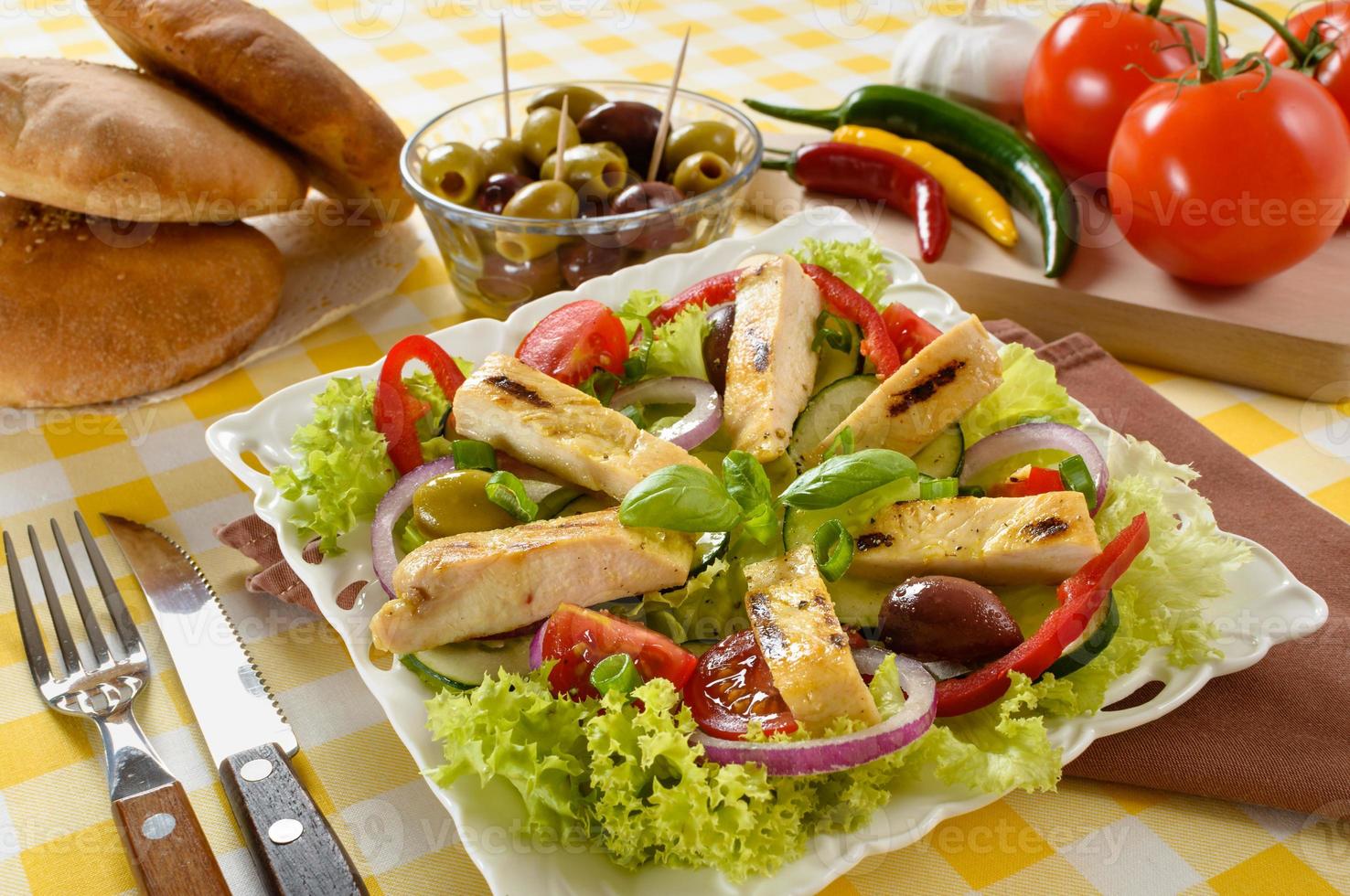 Chicken salad on the plate. Grilled chicken meat with tasty selection of vegetables. photo