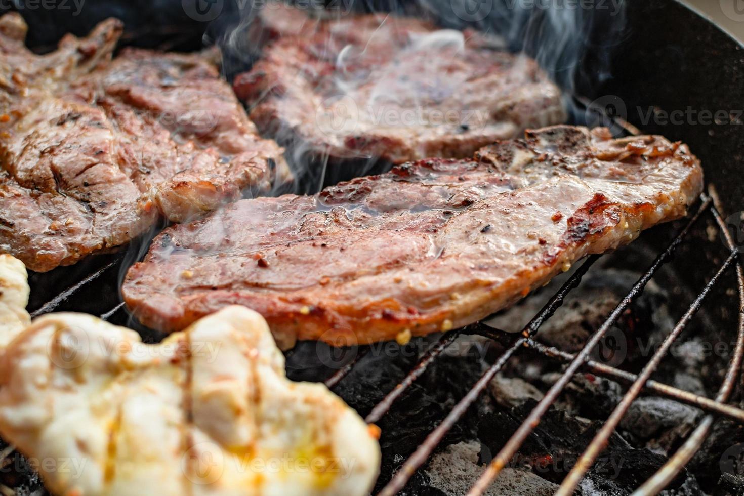 Grilled meat, pork, beef and chicken meat on barbecue, grill. Shallow depth of field. photo