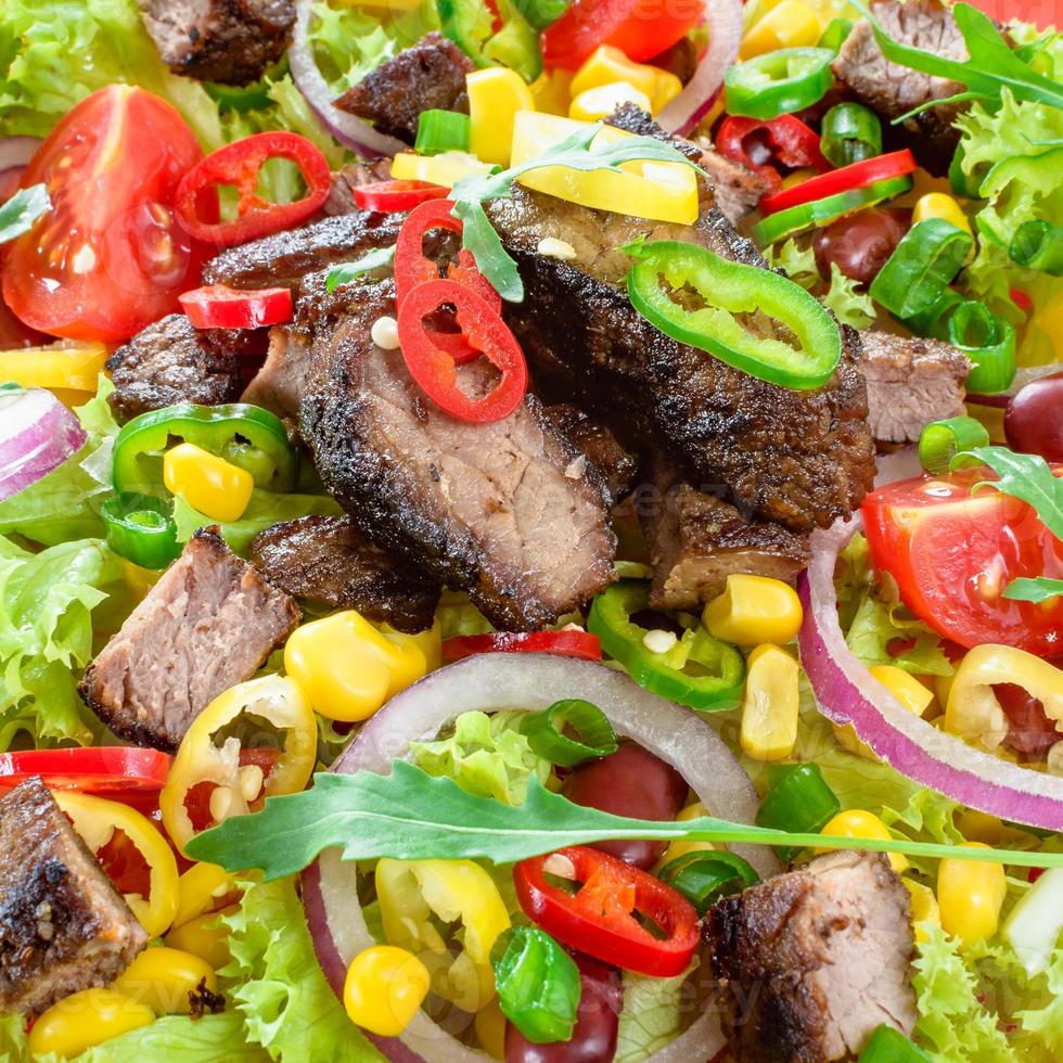 Mexican spicy beef salad on the plate. Grilled beef meat with tasty selection of vegetables. photo