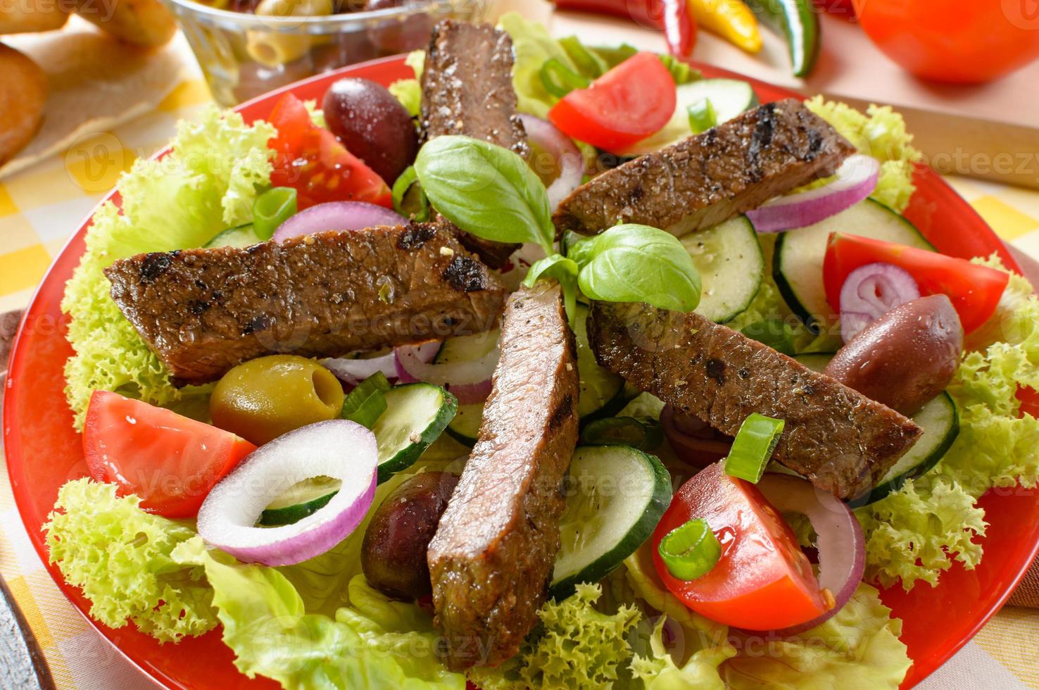 Beef salad on the plate. Grilled beef meat with tasty selection of vegetables. photo