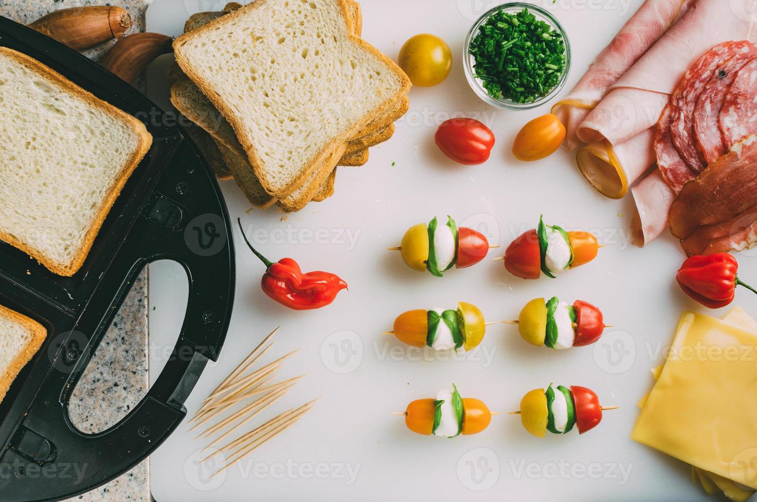 Club sandwich with ham, salami, smoked beef, cheese, lettuce and arugula. Toast sandwich preparation. Top view. photo