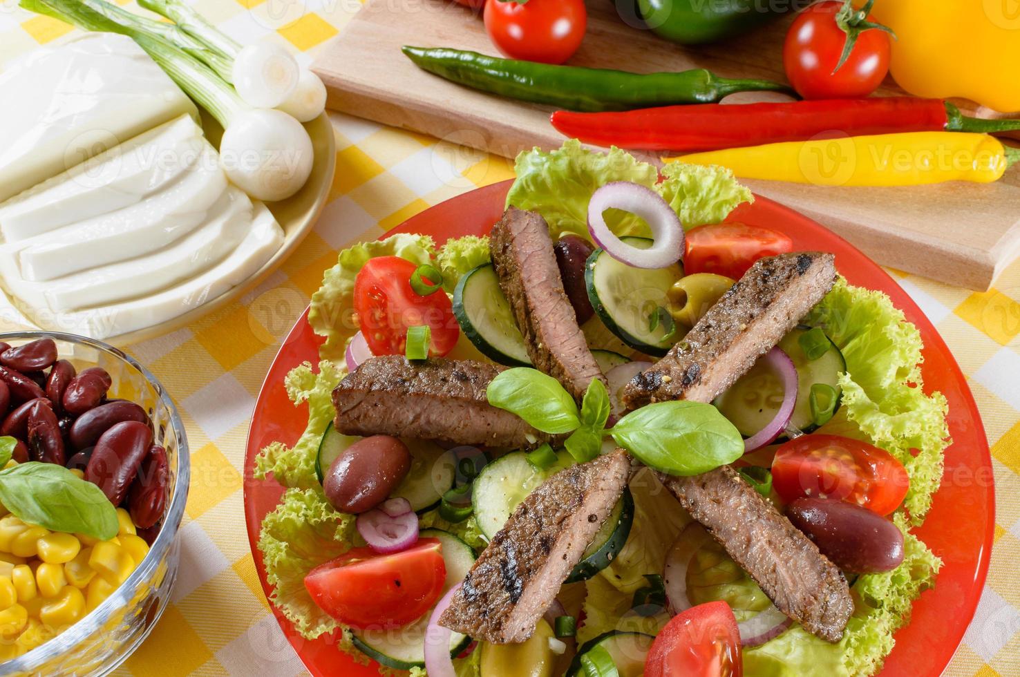 Beef salad on the plate. Grilled beef meat with tasty selection of vegetables. photo