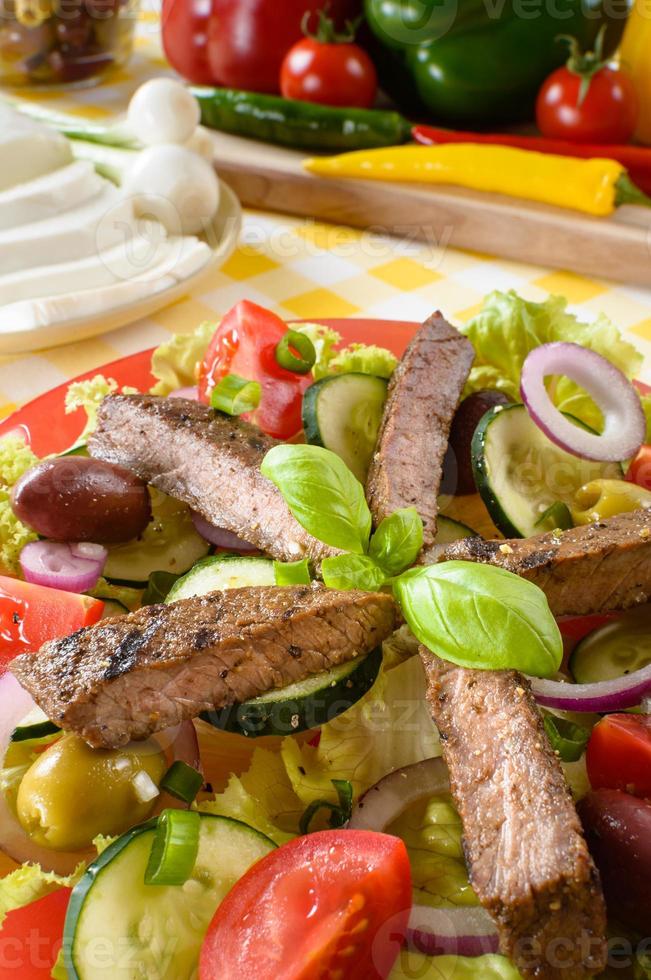 Beef salad on the plate. Grilled beef meat with tasty selection of vegetables. photo