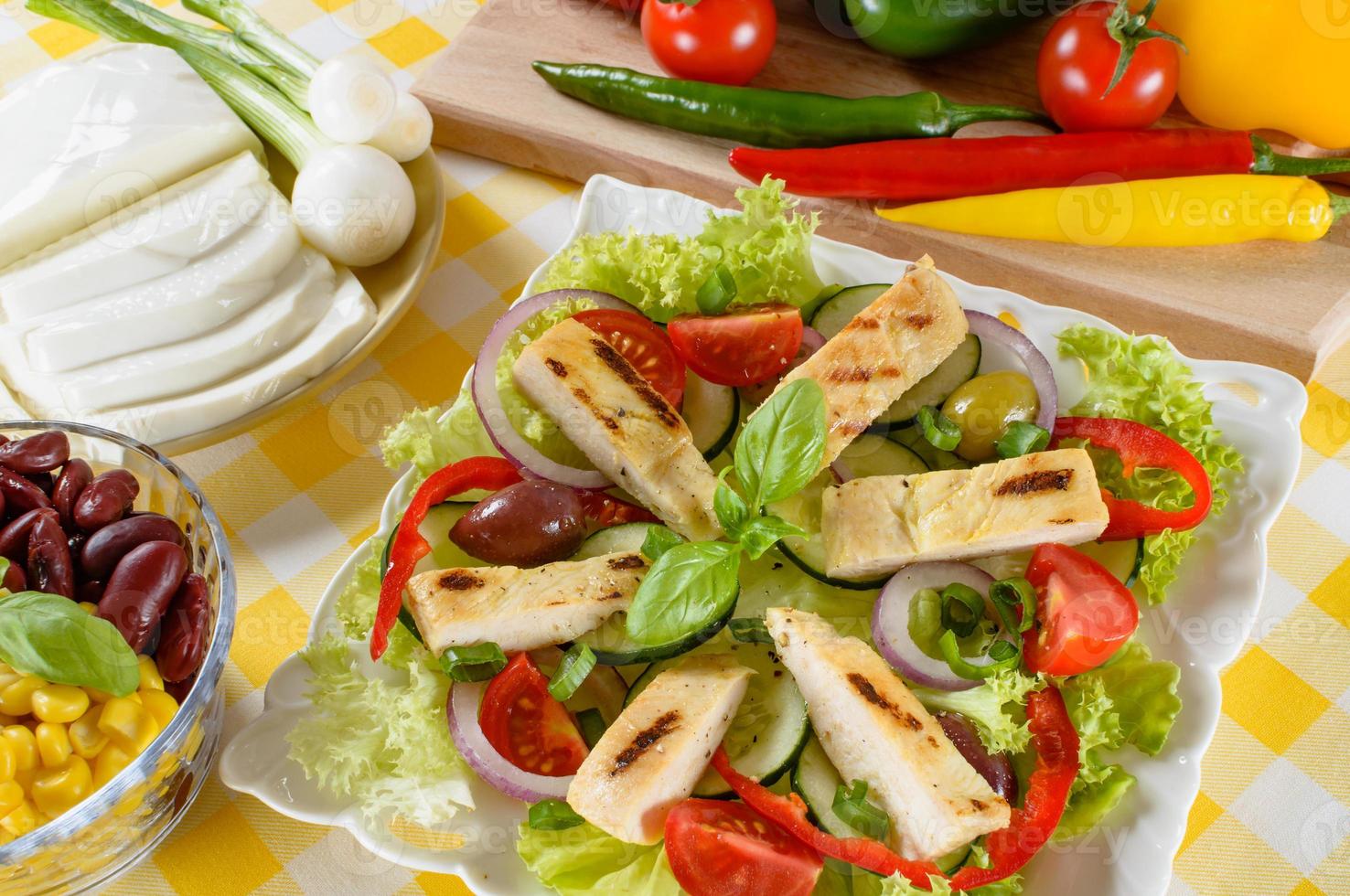 Chicken salad on the plate. Grilled chicken meat with tasty selection of vegetables. photo