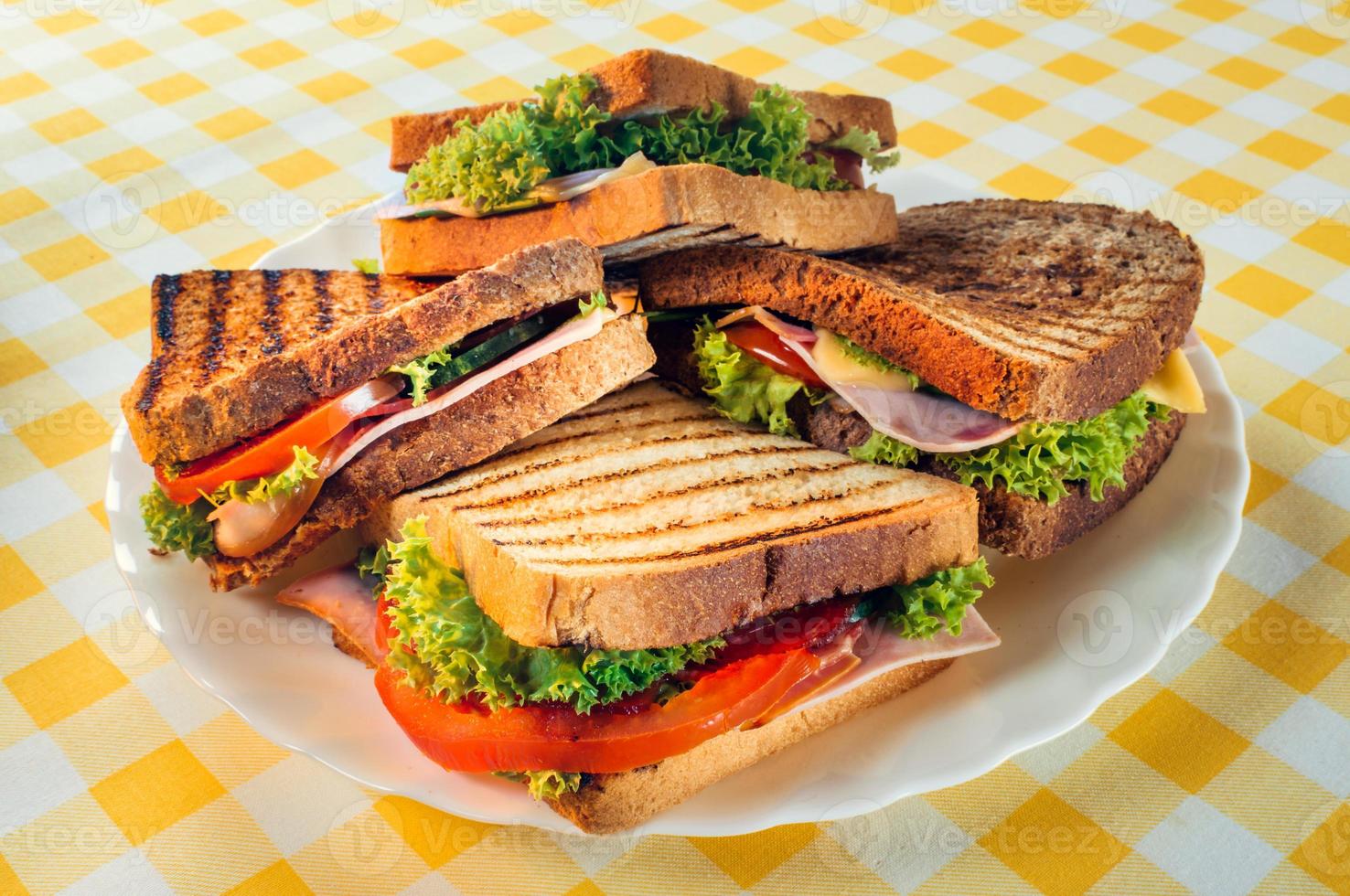 Club sandwich with ham, salami, smoked beef, cheese, lettuce and arugula.Toast sandwich preparation. photo