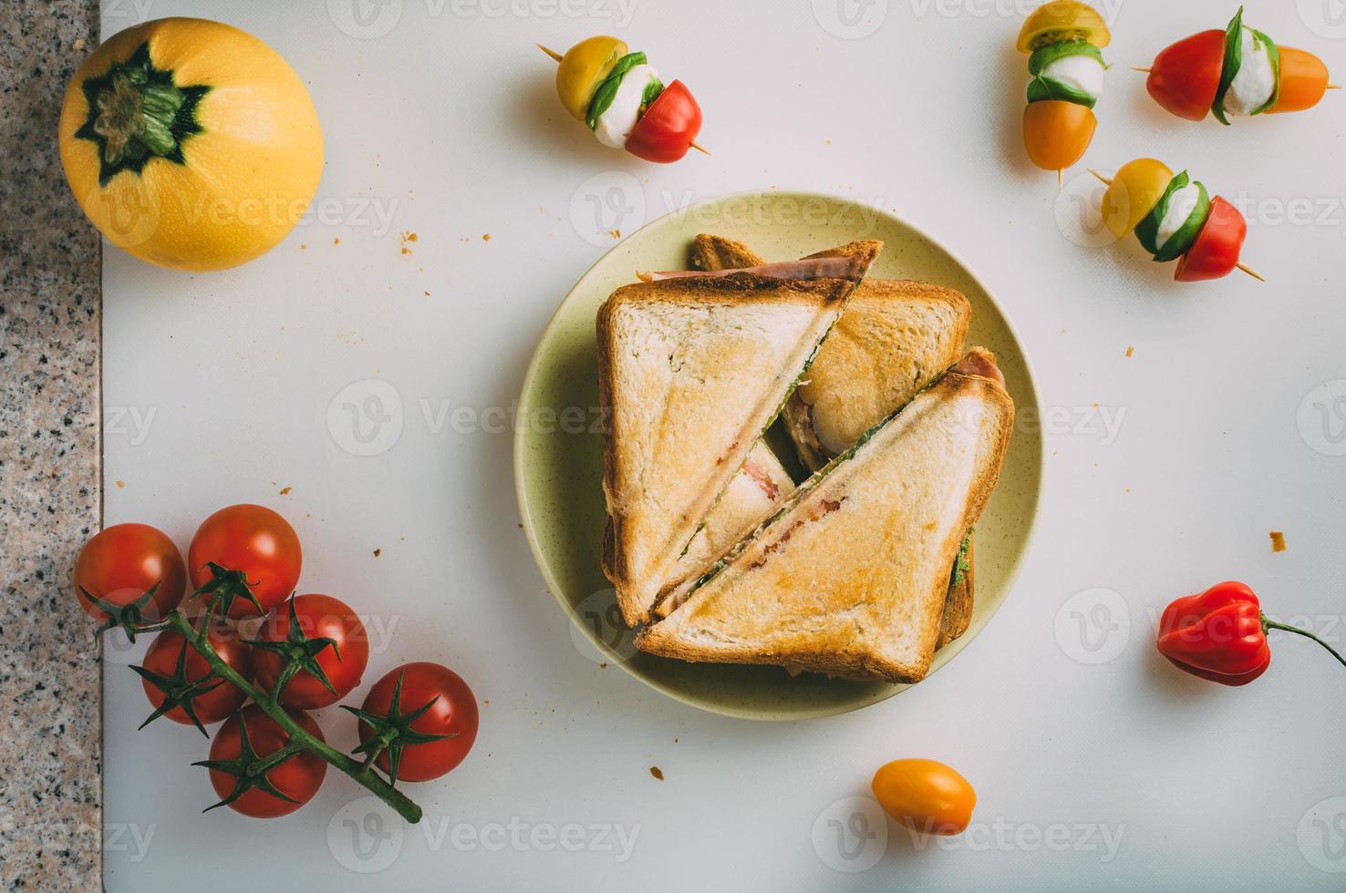 Club sandwich with ham, salami, smoked beef, cheese, lettuce and arugula. Toast sandwich preparation. Top view. photo