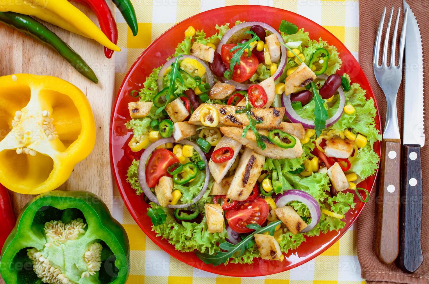 Mexican spicy chicken salad on the plate. Grilled chicken meat with tasty selection of vegetables. photo