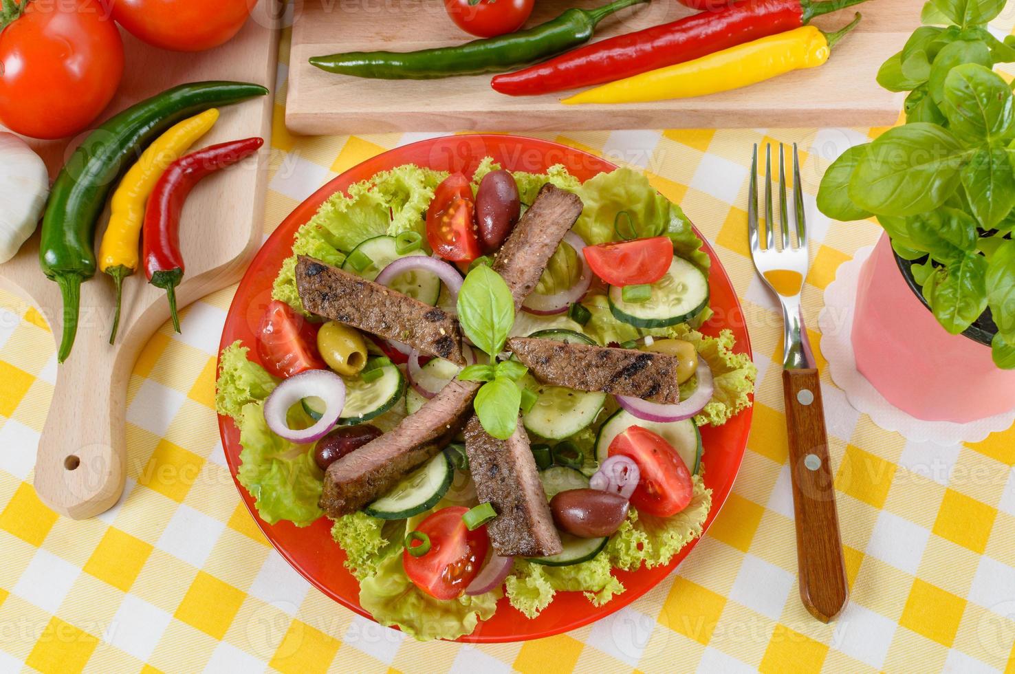 Beef salad on the plate. Grilled beef meat with tasty selection of vegetables. photo