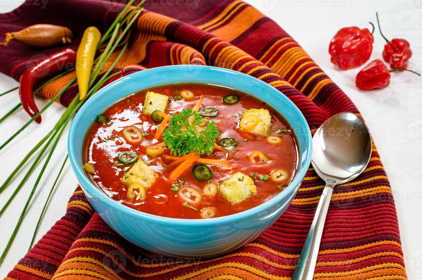 Spicy chili hot tomato soup with bread cubes in a bowl. photo