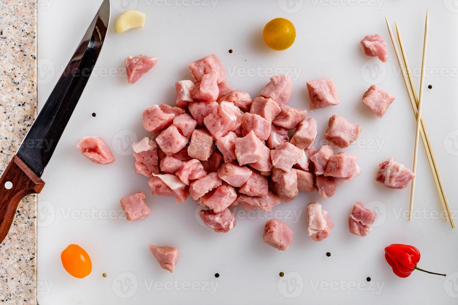 Raw meat, sliced pork steaks on kitchen  table. Meat processing. Skewers preparation. photo
