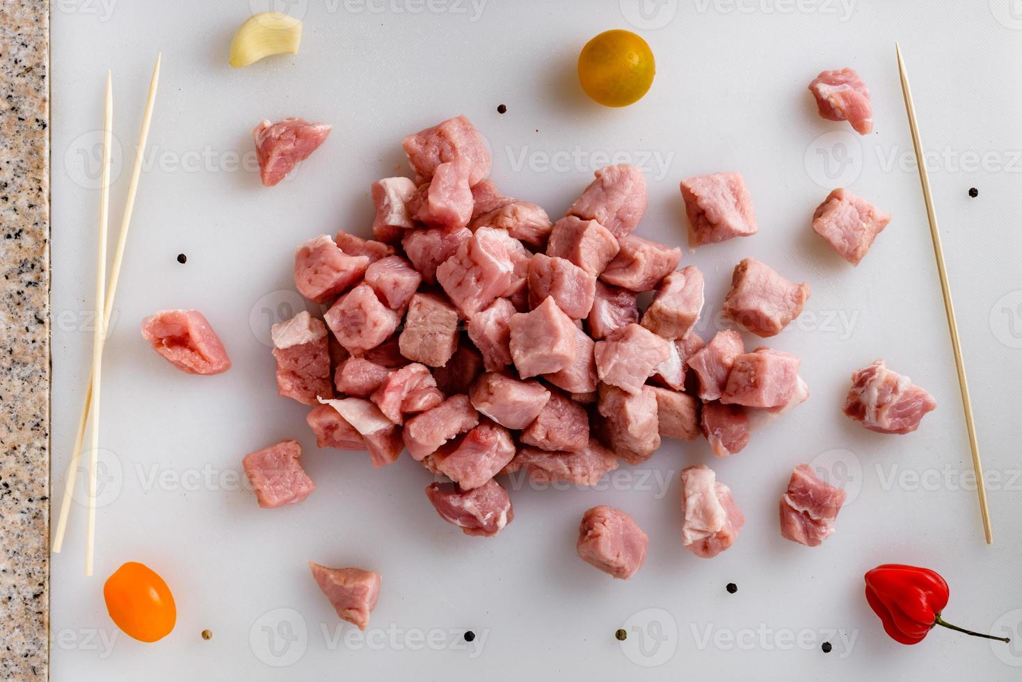 Raw meat, sliced pork steaks on kitchen  table. Meat processing. Skewers preparation. photo