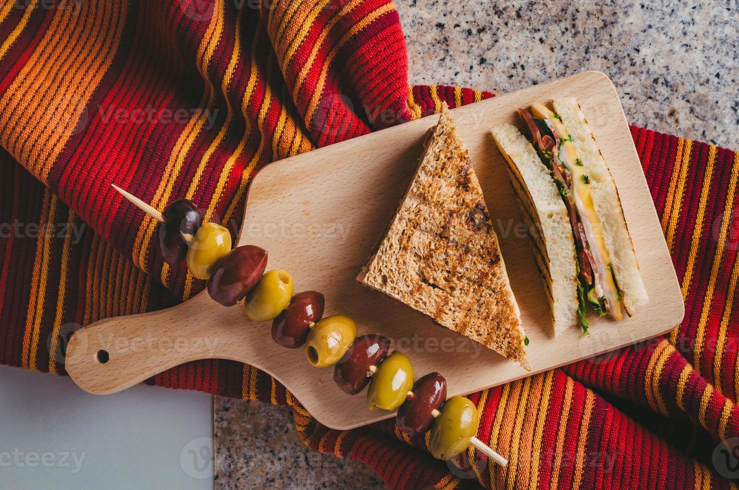 Club sandwich with ham, salami, smoked beef, cheese, lettuce and arugula.Toast sandwich preparation. photo