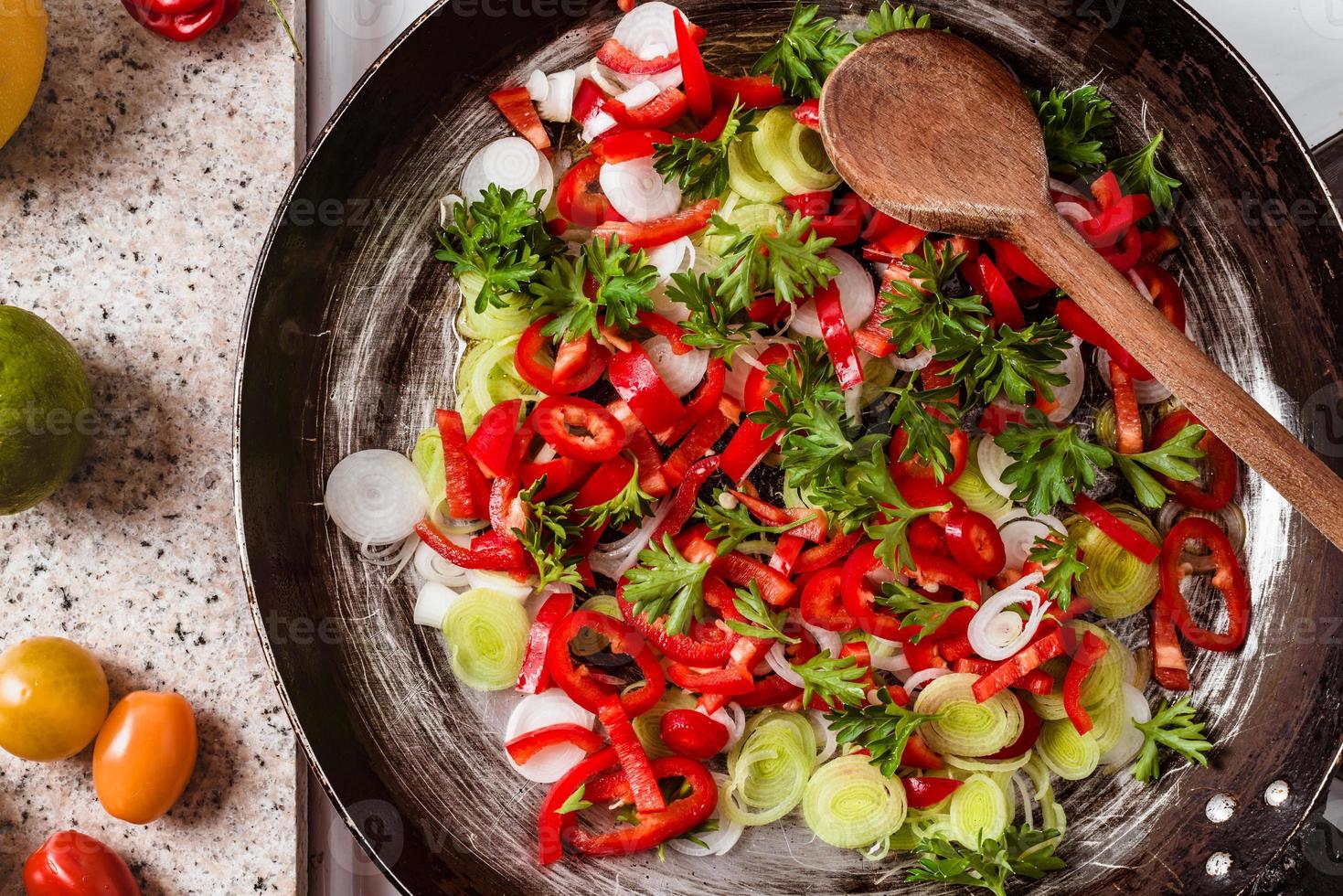 Mix of fresh vegetables fried in the rustic pan, fresh hot chili peppers, tomato and herbs. photo