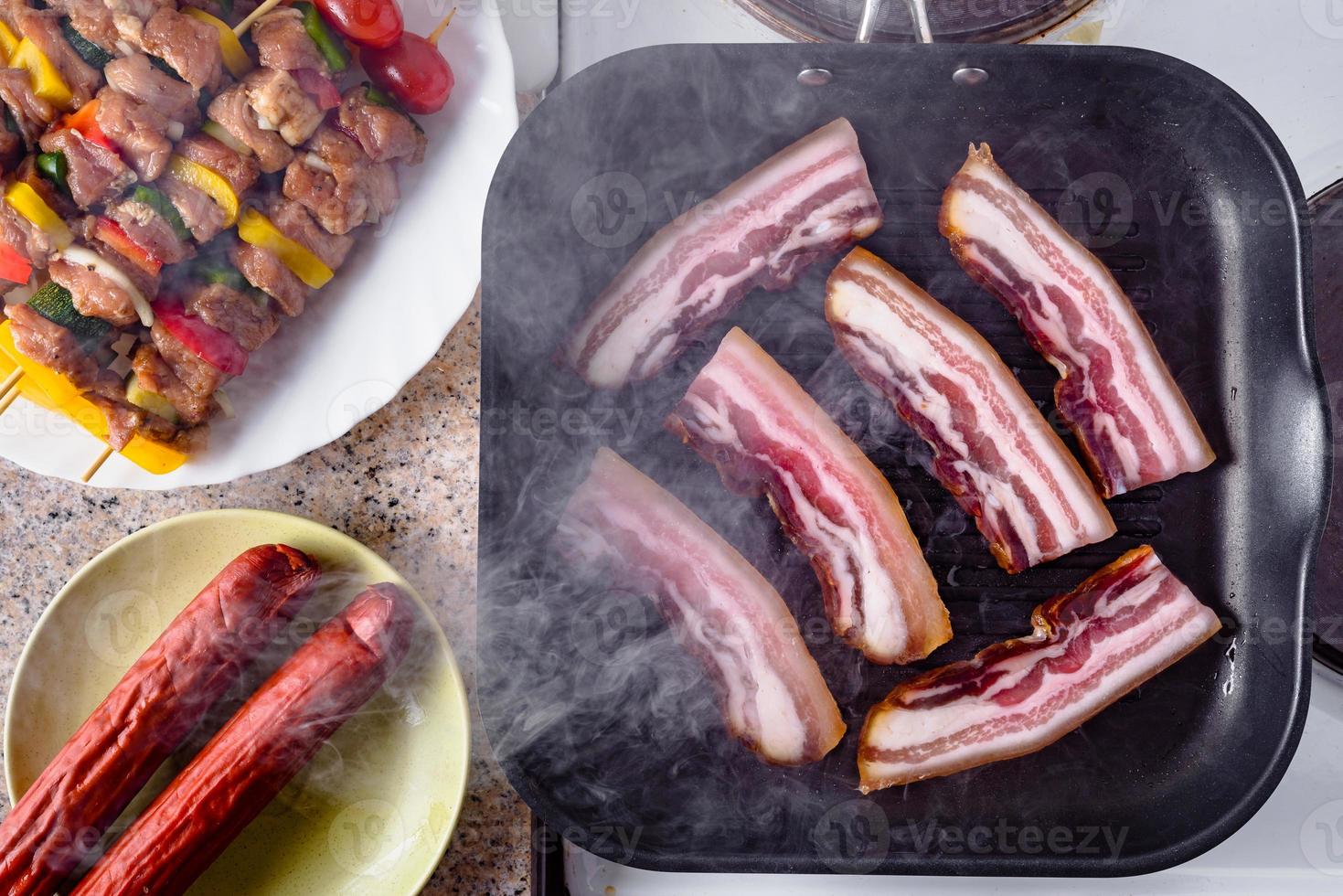 tocino a la plancha. brochetas de salchicha y carne de cerdo cruda listas para asar. foto