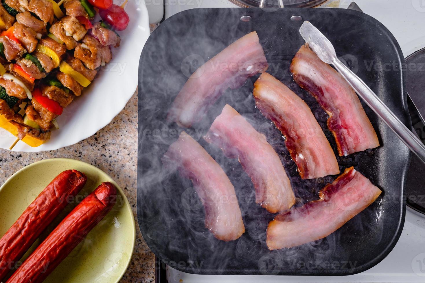 Grilled bacon. Sausage and raw pork skewers ready for grilling. photo