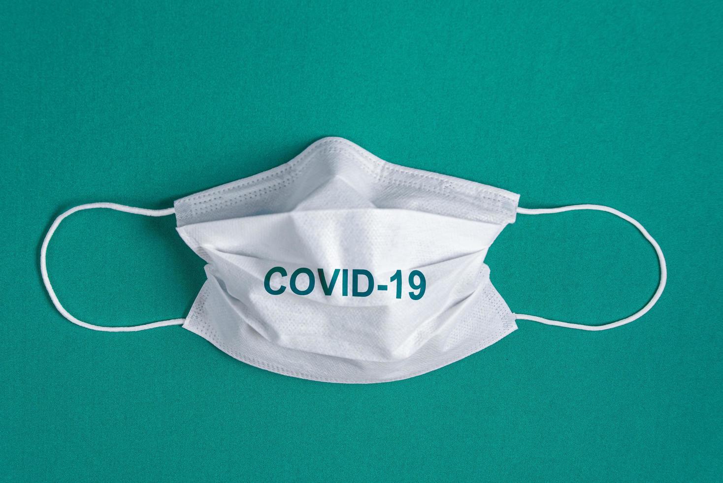 Surgical mask over minimalist green background photo