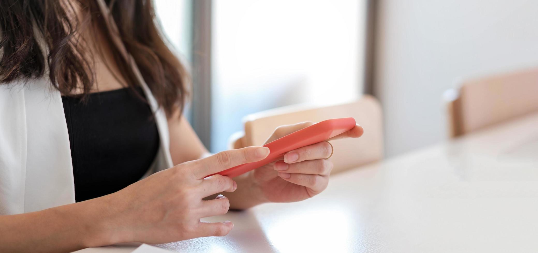 Cerca de una mujer sosteniendo un teléfono inteligente, escribiendo un mensaje, enviando mensajes de texto, chateando, manos femeninas usando el teléfono celular, navegando por aplicaciones móviles, Internet, revisando las redes sociales, correo electrónico, jugando juegos en el teléfono foto