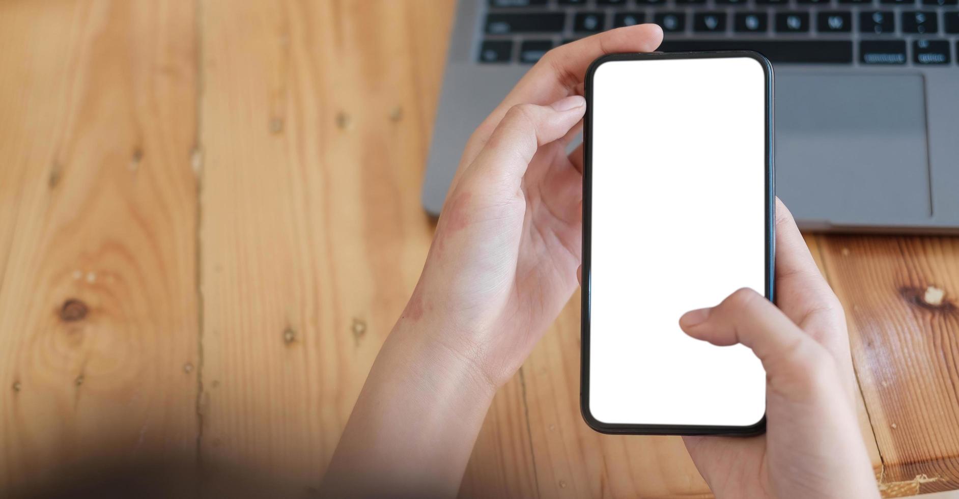Mockup image of a person holding a cell phone with a blank white screen for text photo