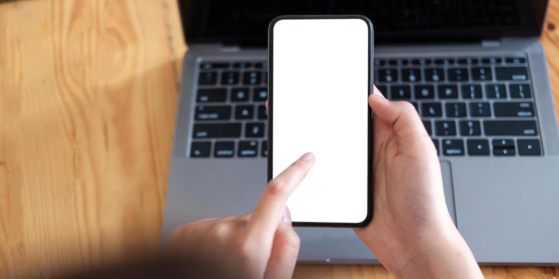 Mockup image of a person holding a cell phone with a blank white screen for text photo