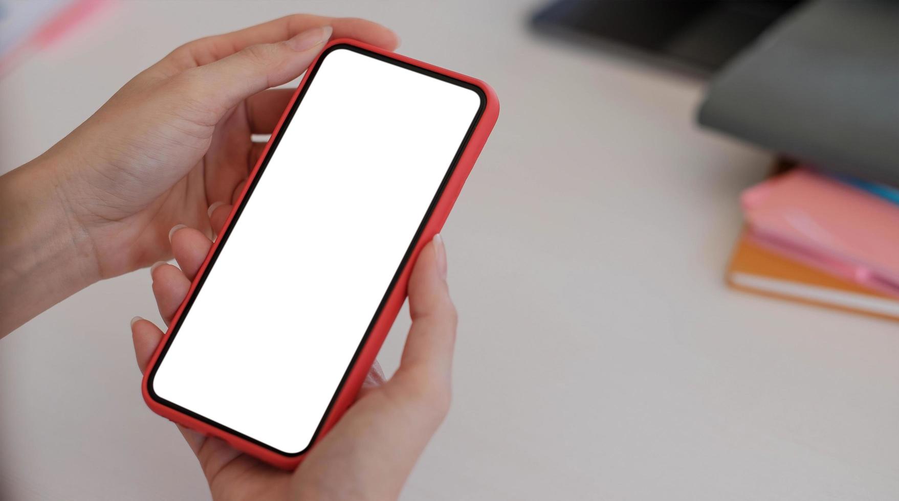 Woman holding a smartphone with a white screen mock up photo
