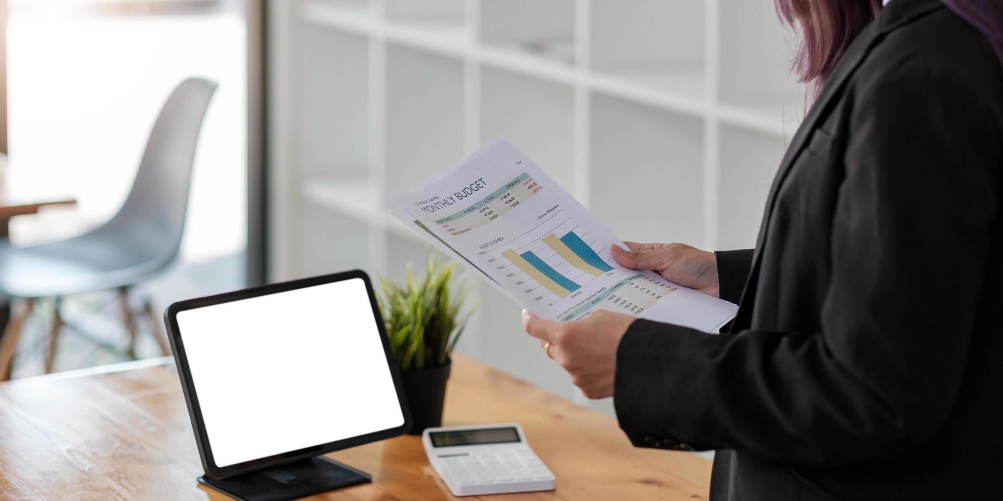 Businesswoman holding paperwork on the desk in co-working space photo