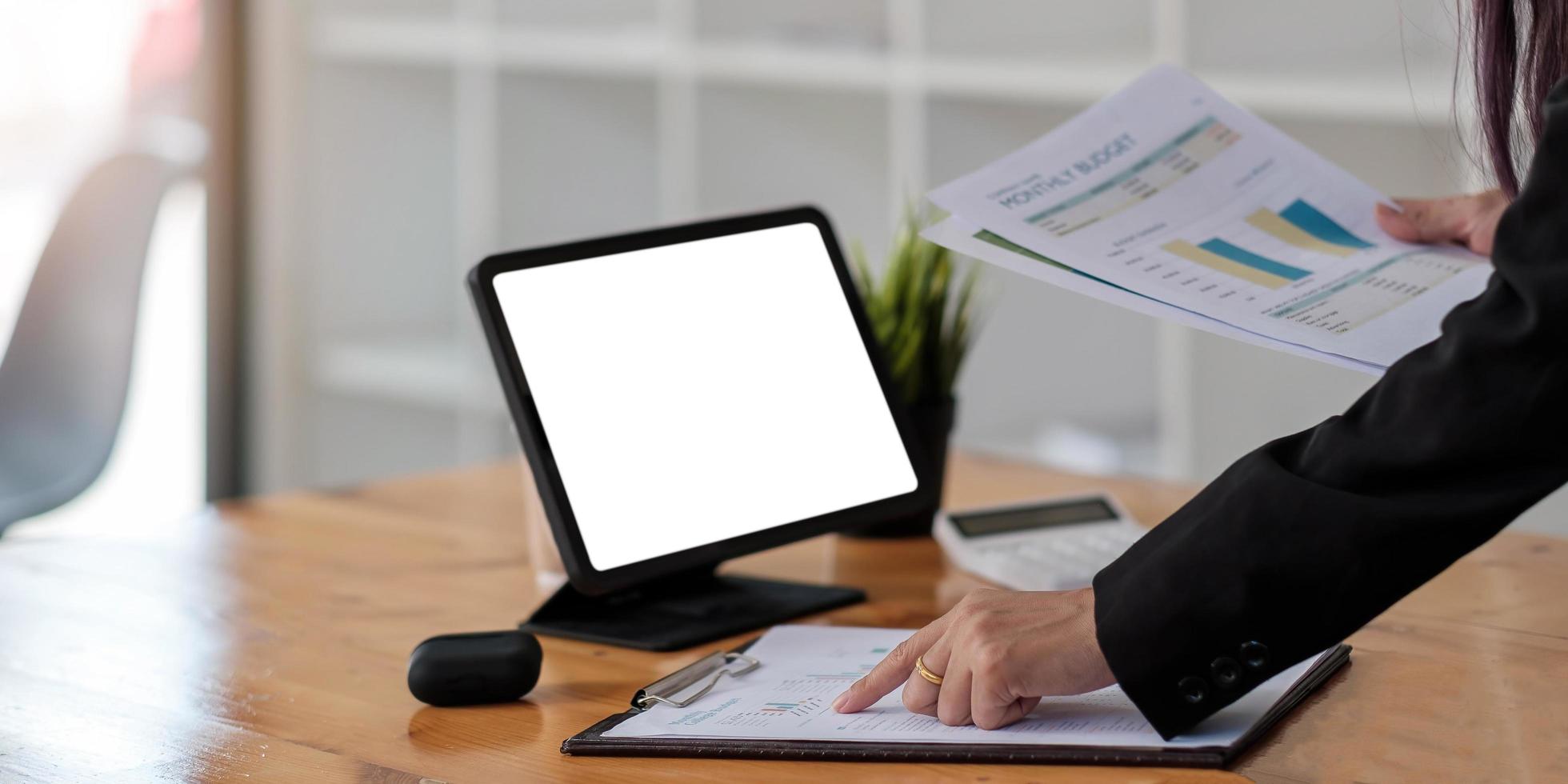 Businesswoman points on papers and holding papers preparing a report photo