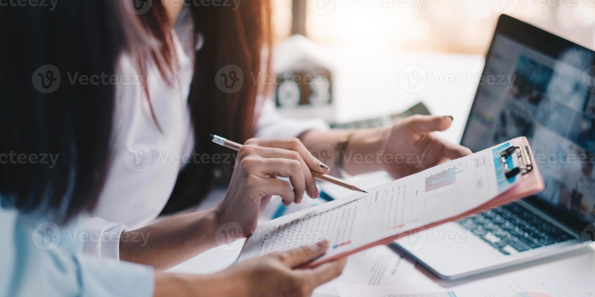 Cerca de empresarios discutiendo los cuadros y gráficos que muestran los resultados de su exitoso trabajo en equipo foto