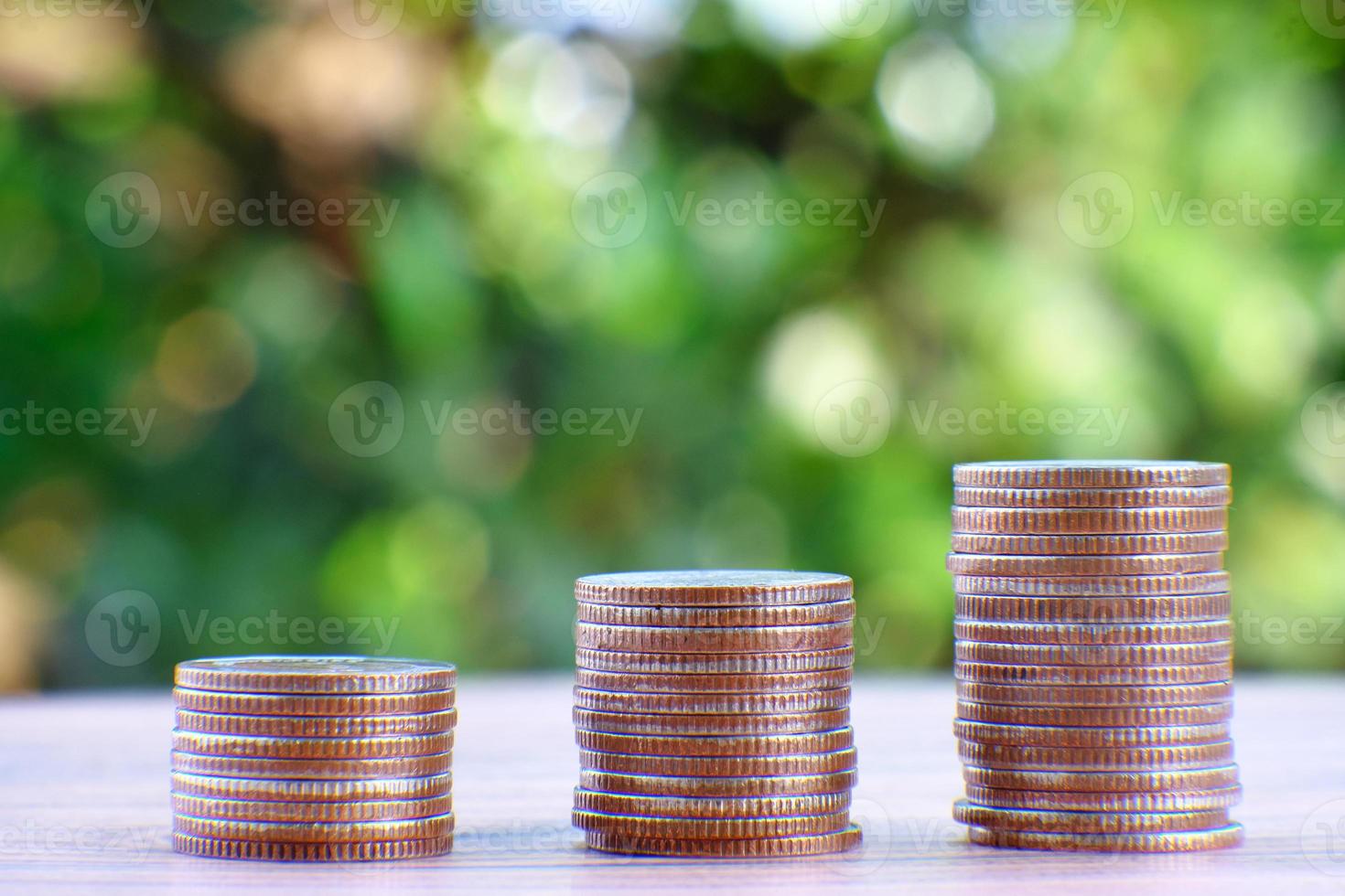 Pila de monedas sobre un fondo verde de la naturaleza foto