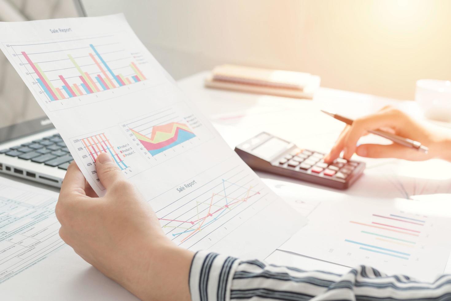 Businesswoman using a calculator and writing notes. Taxes, savings, finances, and economy concept photo