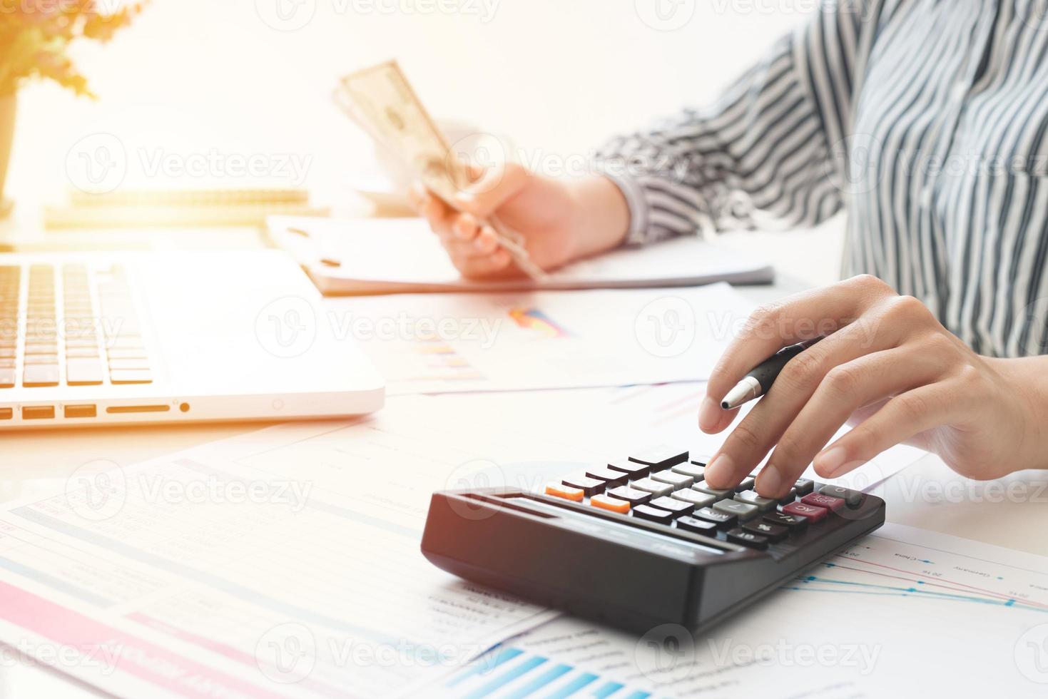 empresaria usando una calculadora y escribiendo notas. impuestos, ahorros, finanzas y concepto de economía foto