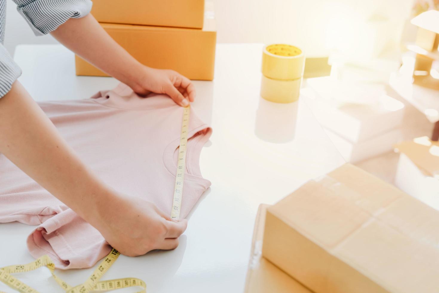 Vista de cerca de la tienda en línea de la mujer, vendedor propietario de una pequeña empresa, paquete de embalaje del empresario, caja de envío postal que prepara el paquete de entrega sobre la mesa, concepto de negocio autónomo empresarial foto