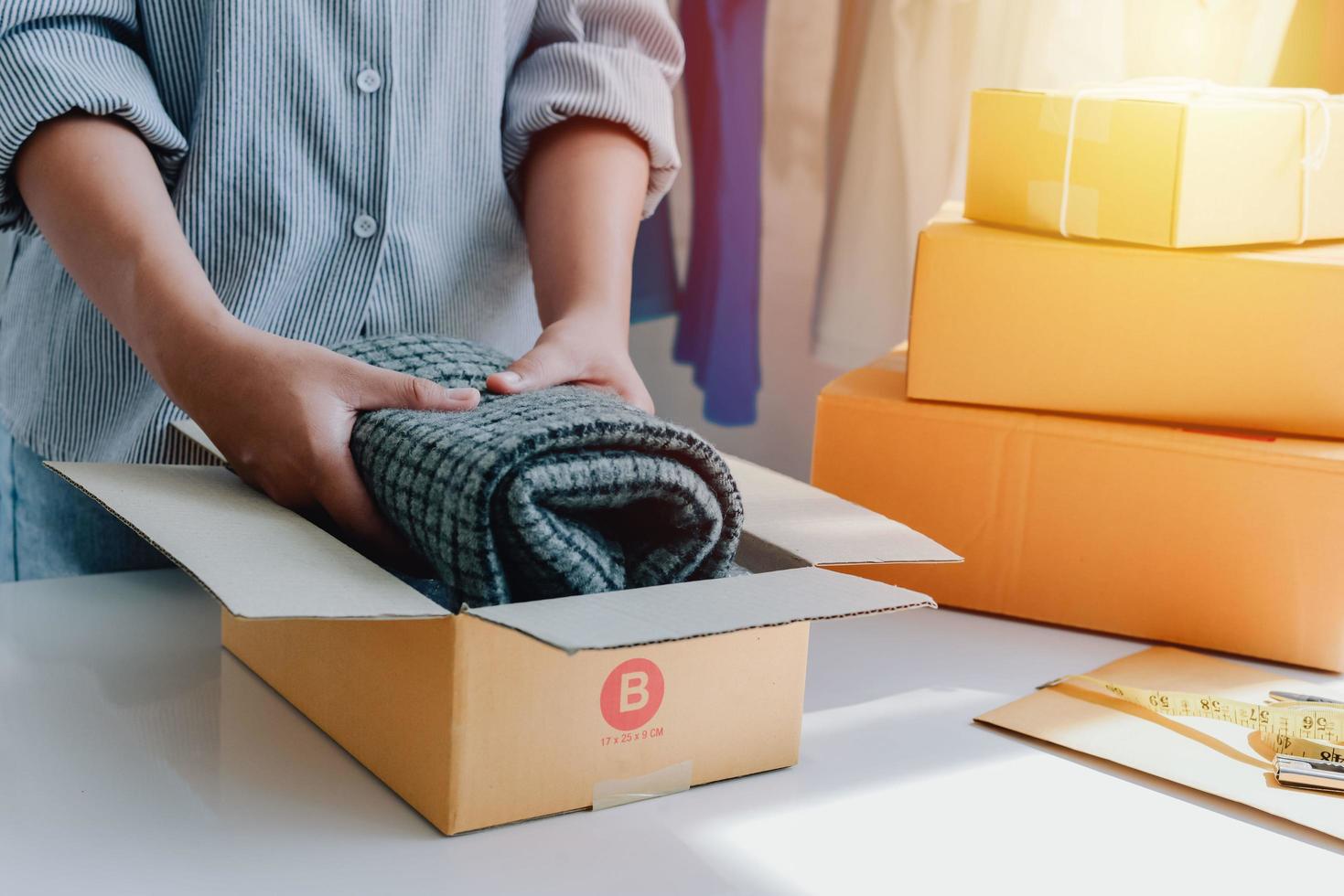 Closeup view of female's online store, small business owner seller, entrepreneur packing package, post shipping box preparing delivery parcel on the table, entrepreneurial self-employed business concept photo