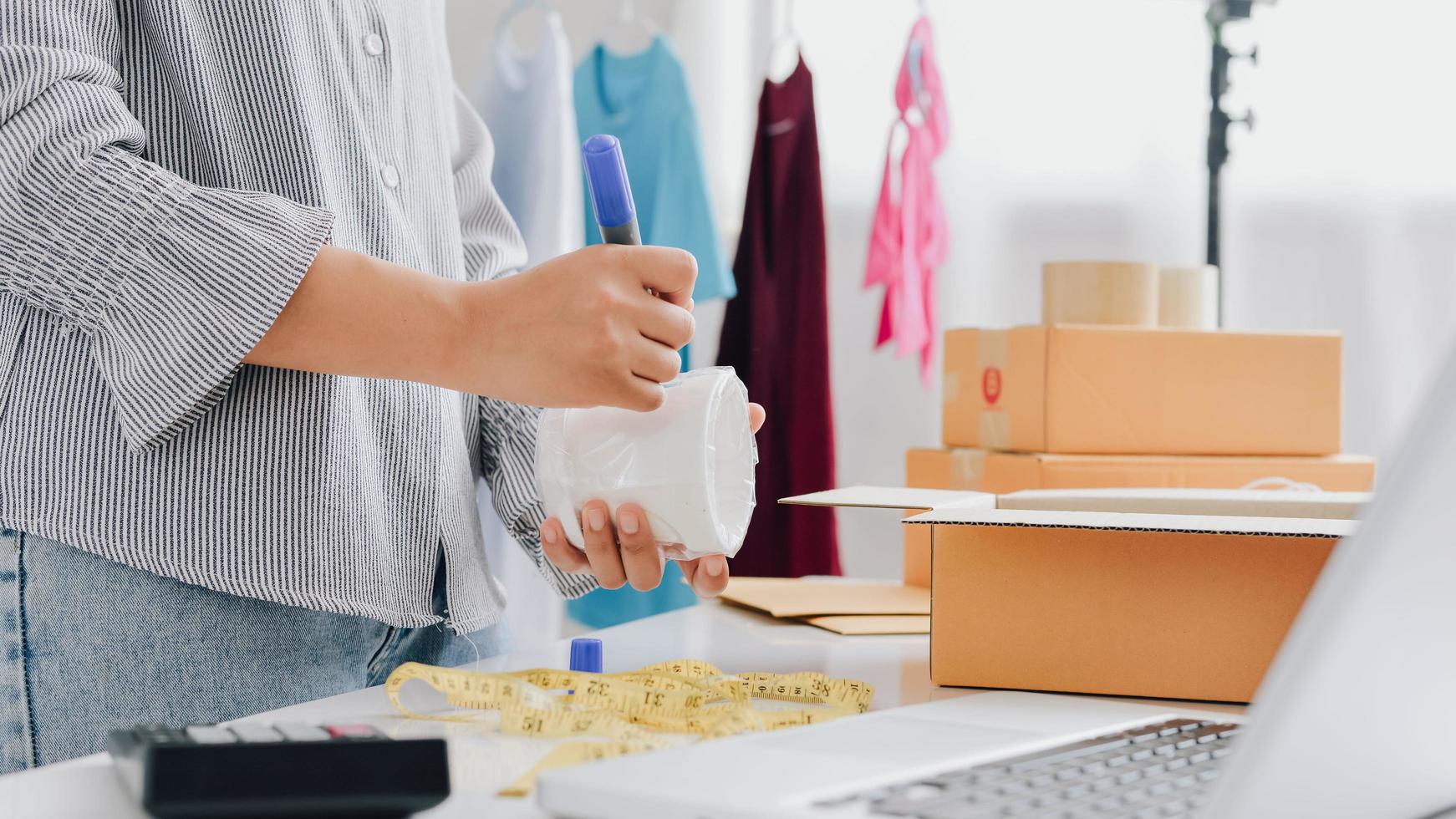 Closeup view of female's online store, small business owner seller, entrepreneur packing package, post shipping box preparing delivery parcel on the table, entrepreneurial self-employed business concept photo