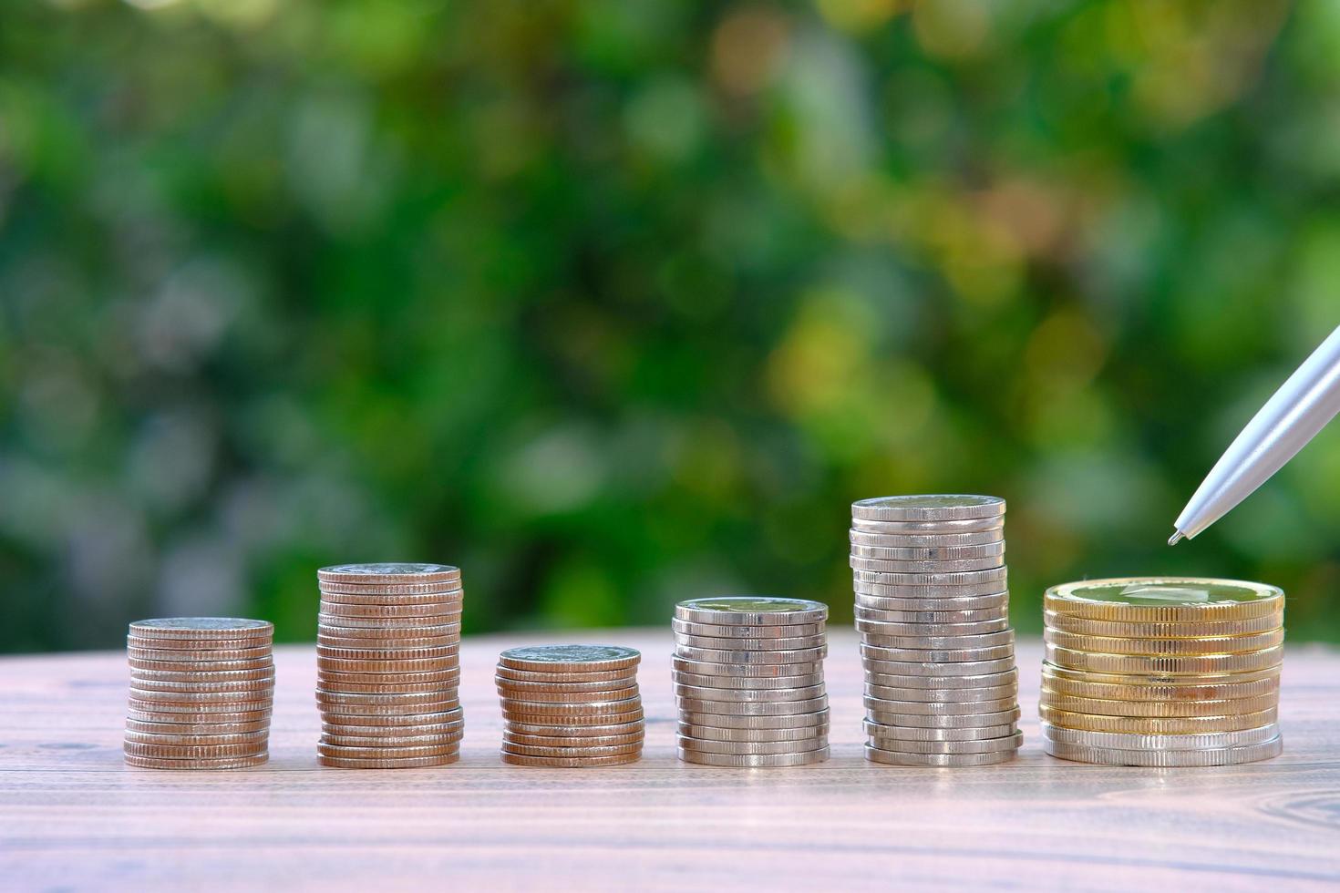 Stack of coins on a green nature background photo