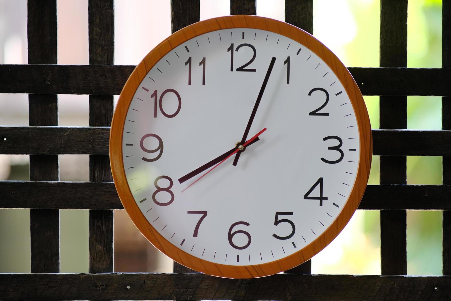 Wall clock on wood background and time concept photo