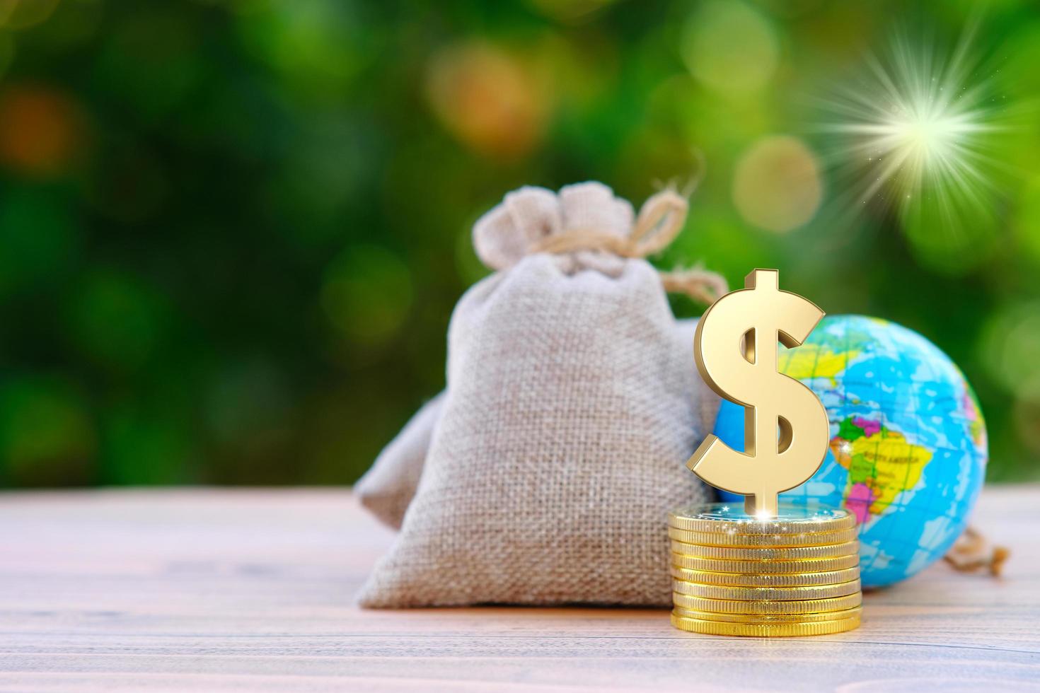 Money bag with coins and a globe on a bokeh nature background photo