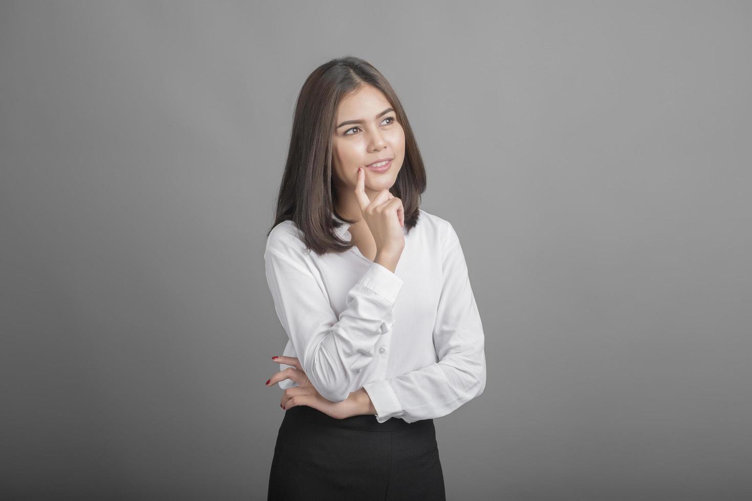 hermosa mujer de negocios pensando en fondo gris foto