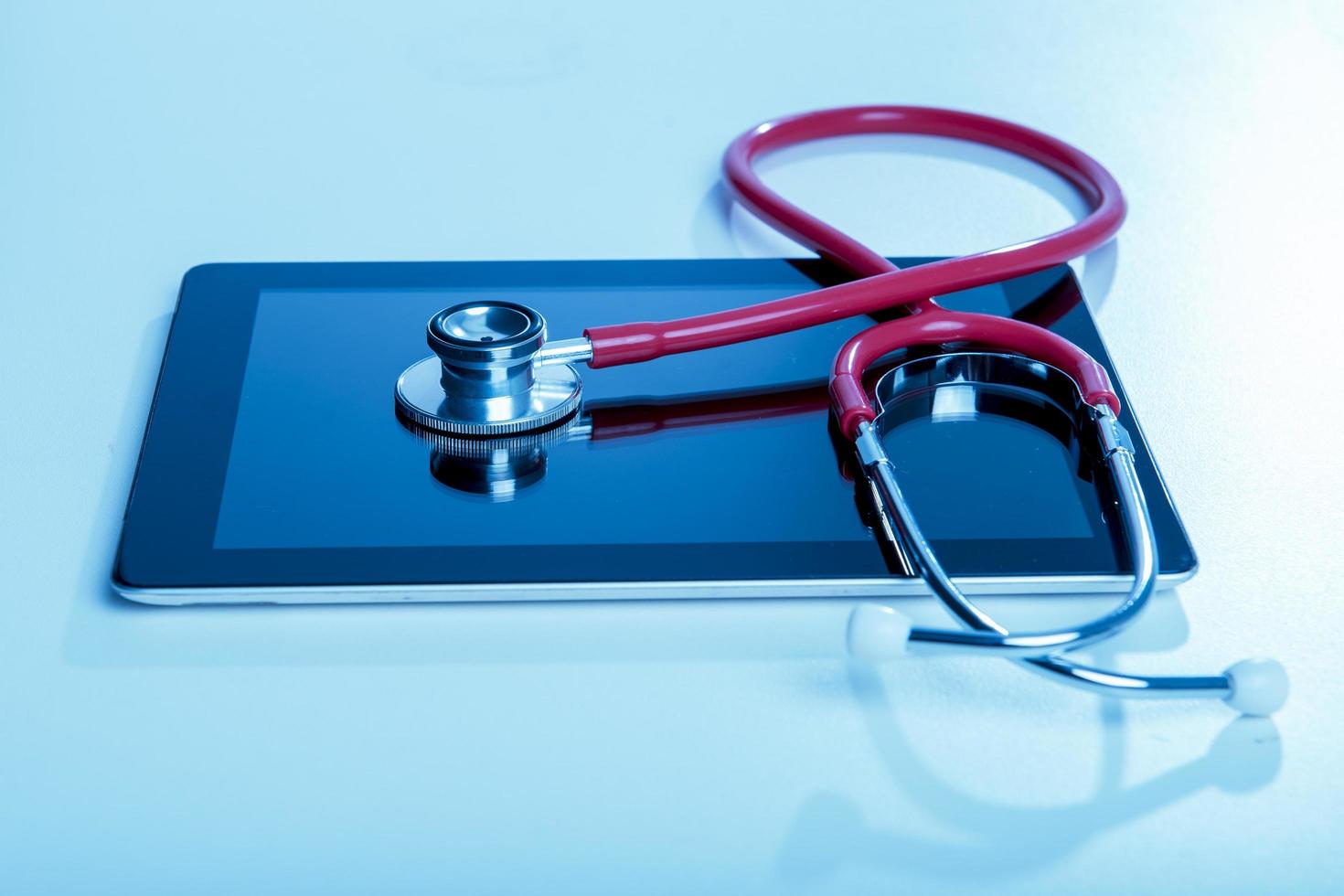 Stethoscope with tablet computer on blue background photo