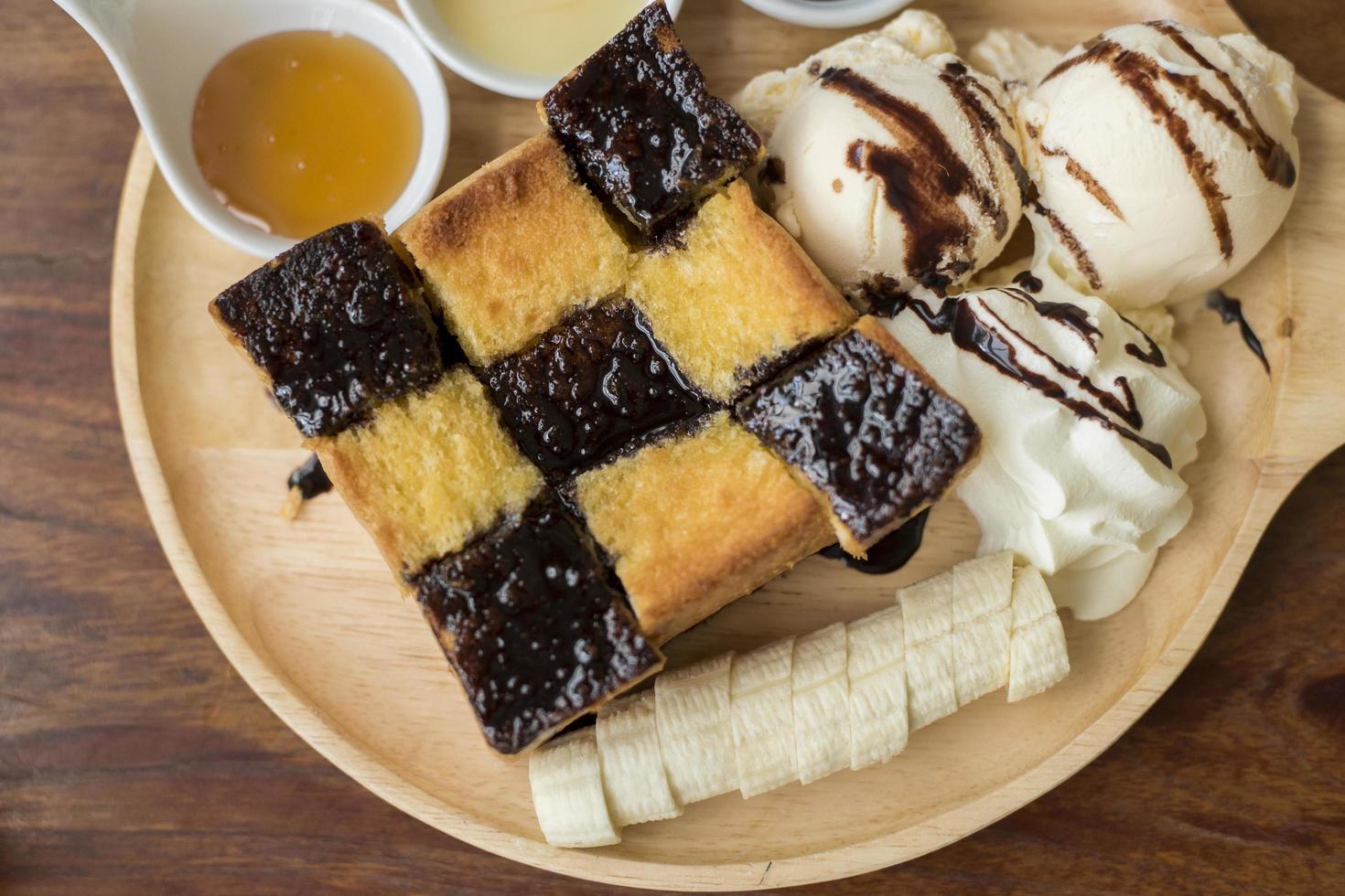 Honey toast with vanilla ice cream, whipped cream and chocolate syrup. Served with banana photo