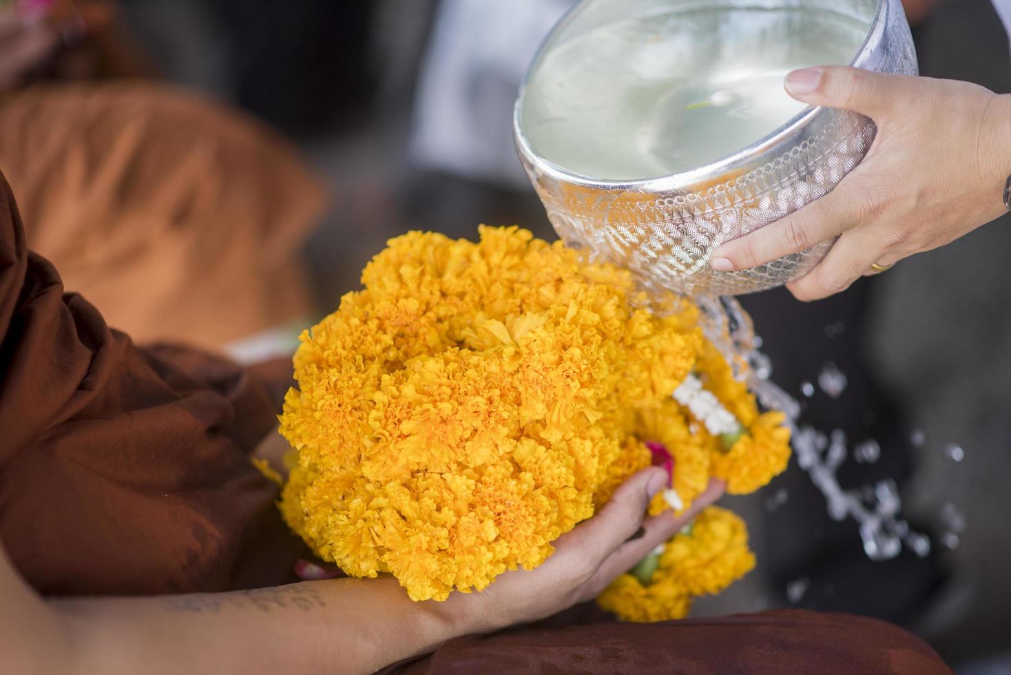 Water in water dipper with colorful flowers pedestal for Songkran festival, Thailand photo