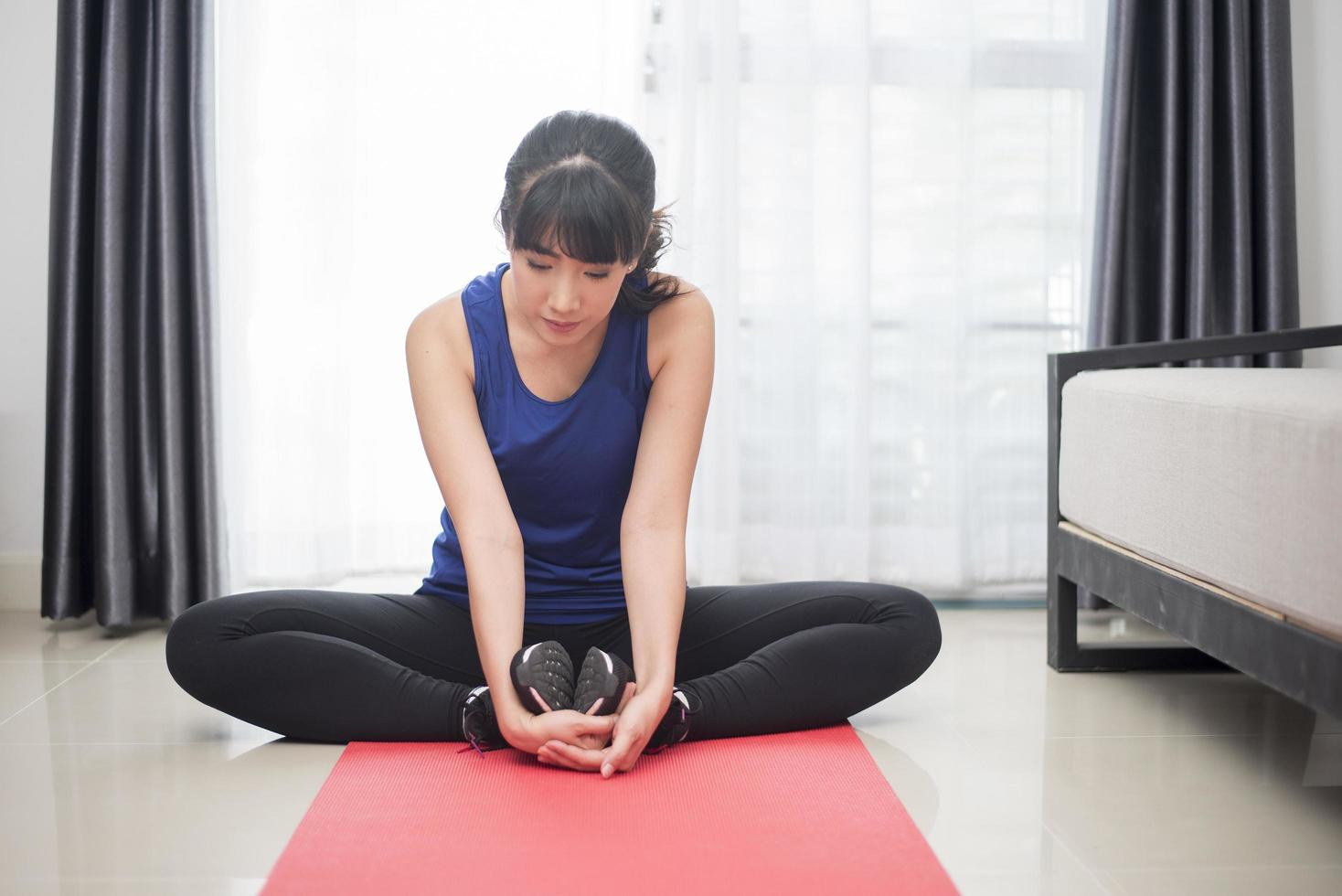 Beautiful Young sporty woman stretching at home photo