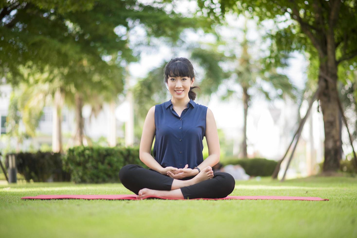 Beautiful yoga woman on green park photo