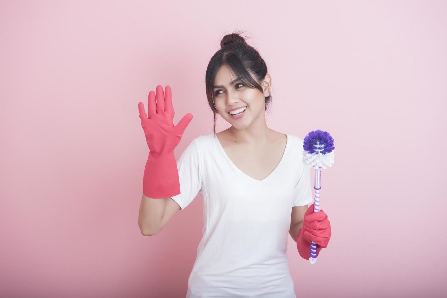 Beautiful asian housewife smiling on pink background photo