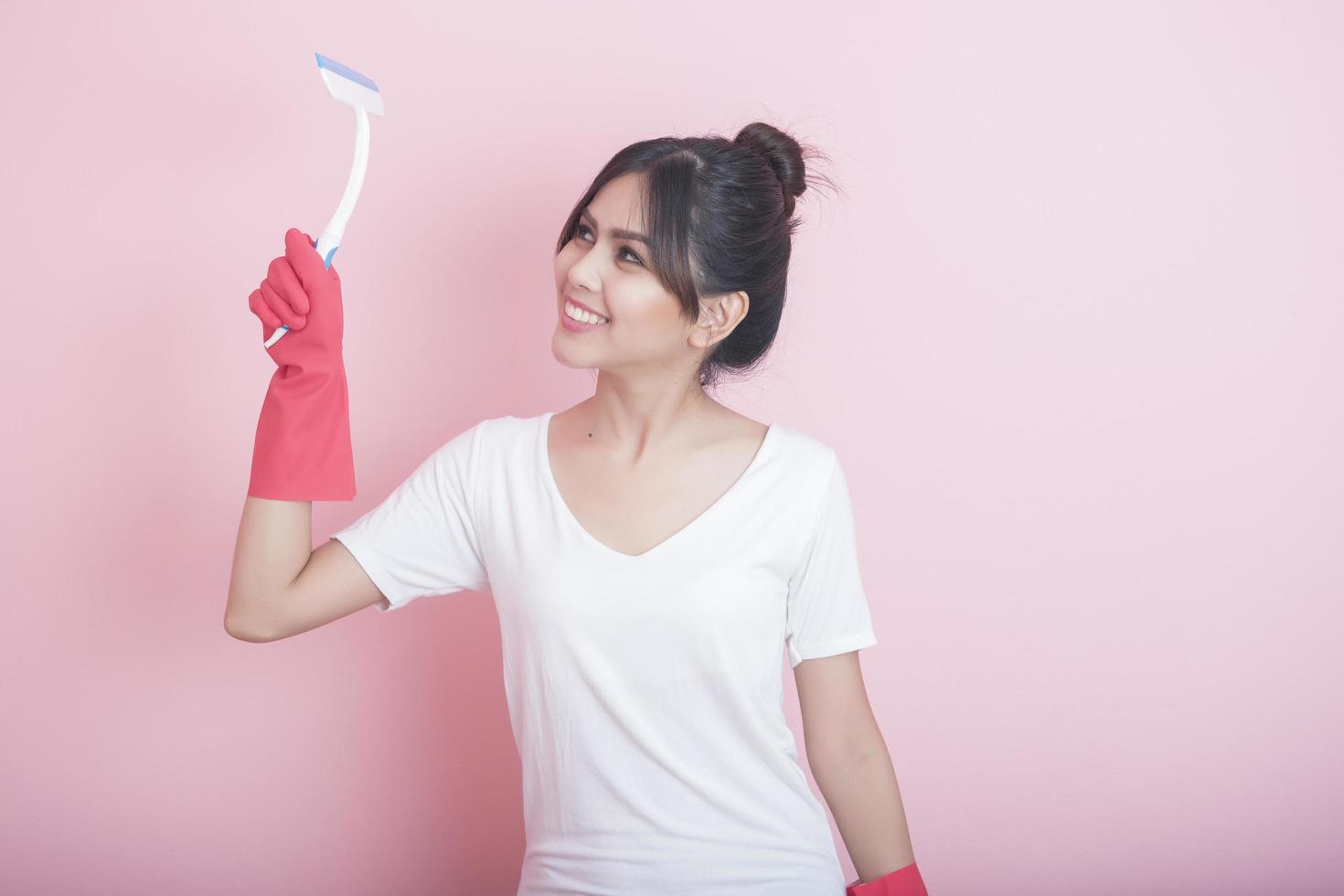 Beautiful asian housewife smiling on pink background photo