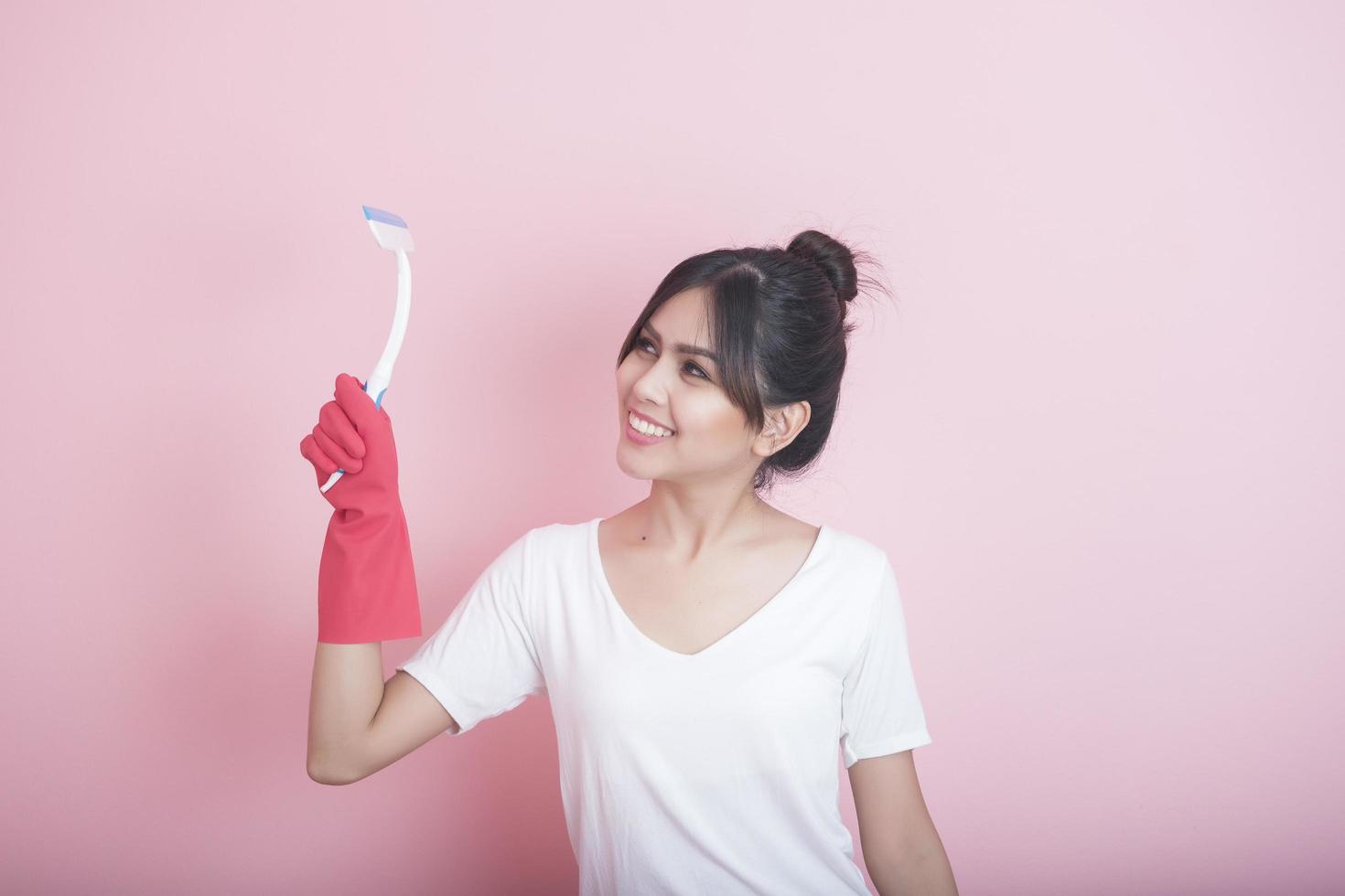 Beautiful asian housewife smiling on pink background photo