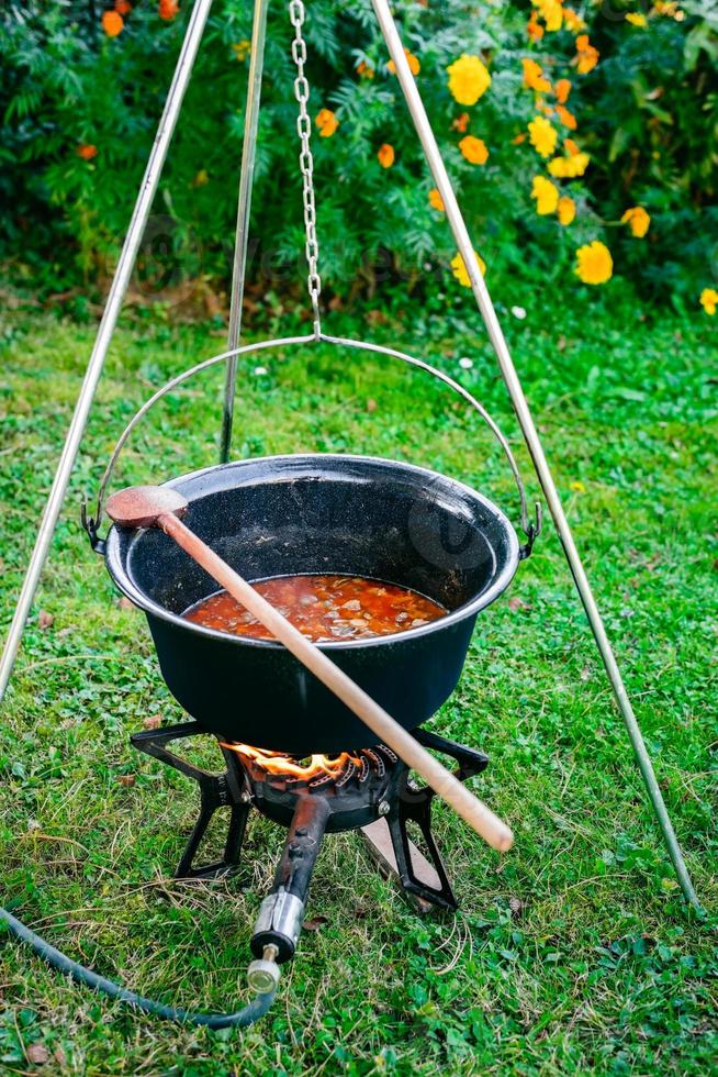 Cooking beef goulash soup in a cauldron photo