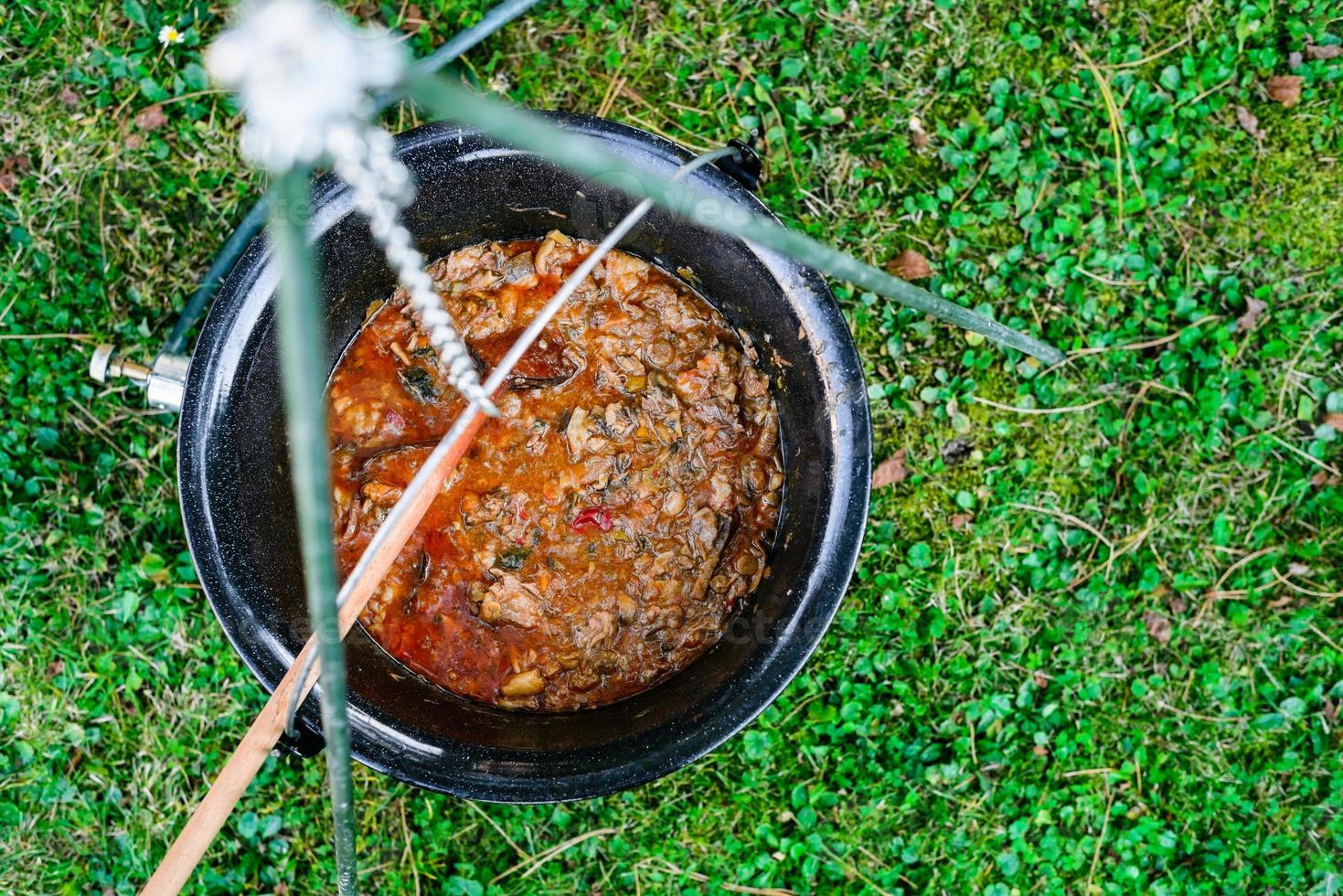 Cooking beef goulash soup in a cauldron photo