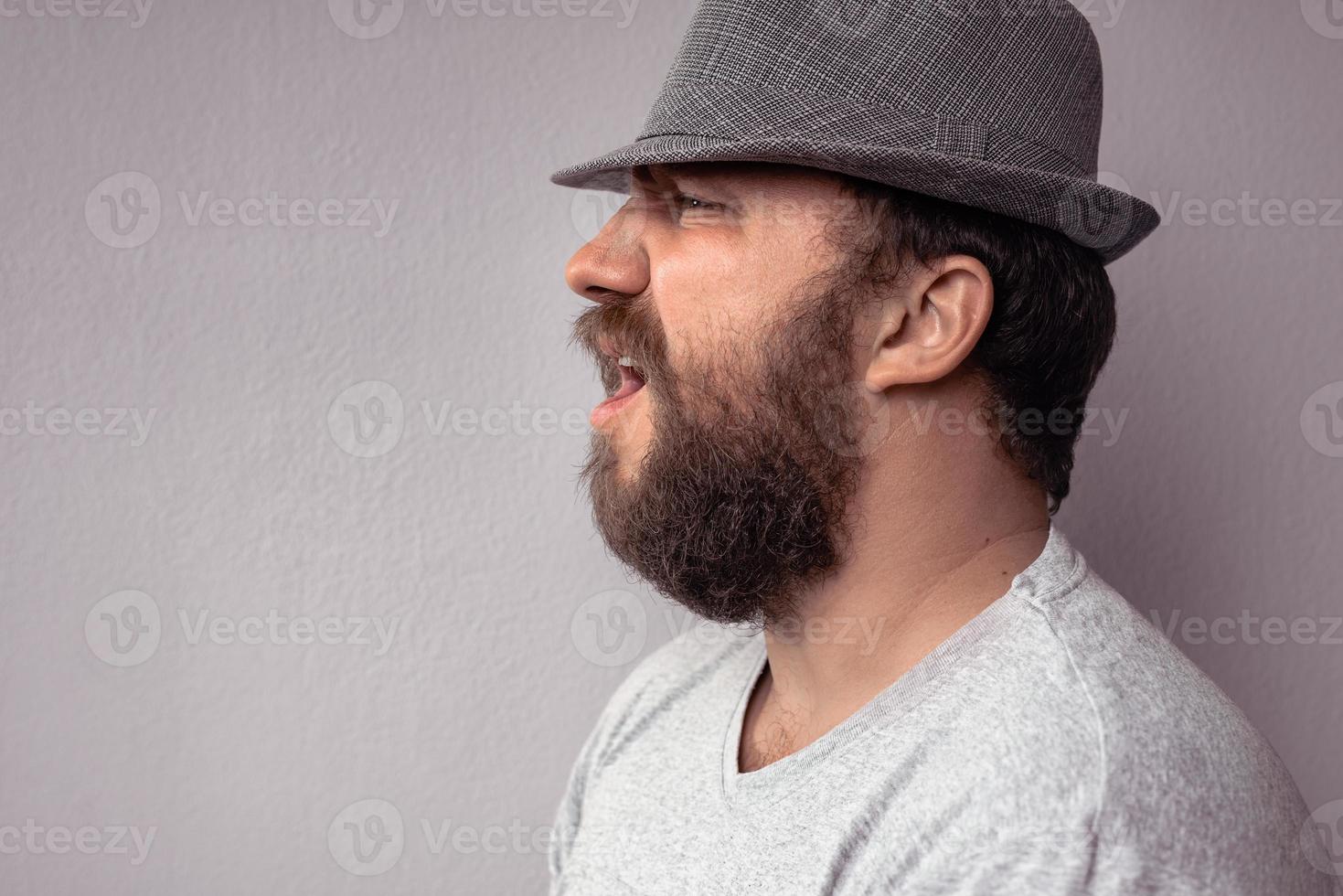 Side portrait of a bearded man shouting photo