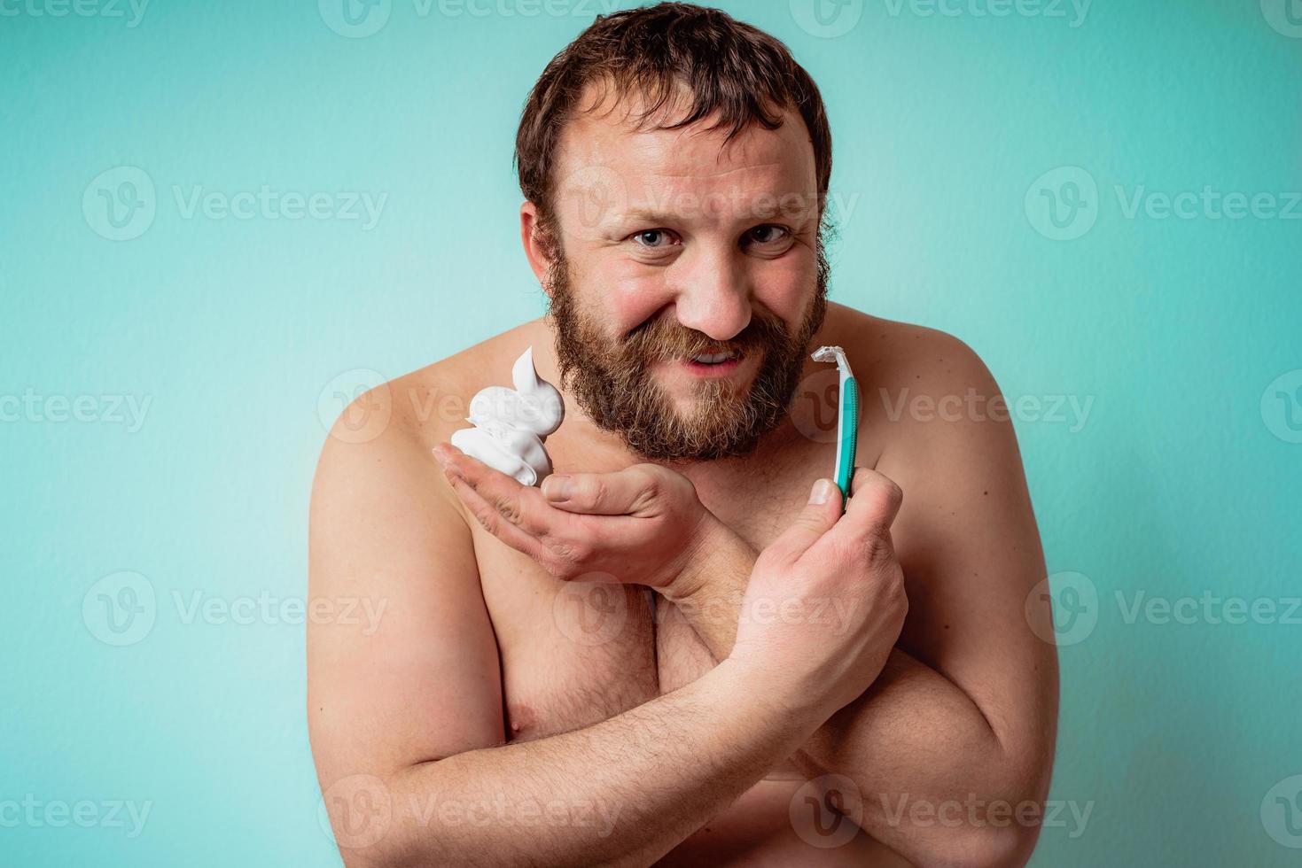 feliz chico barbudo está listo para afeitarse la barba foto